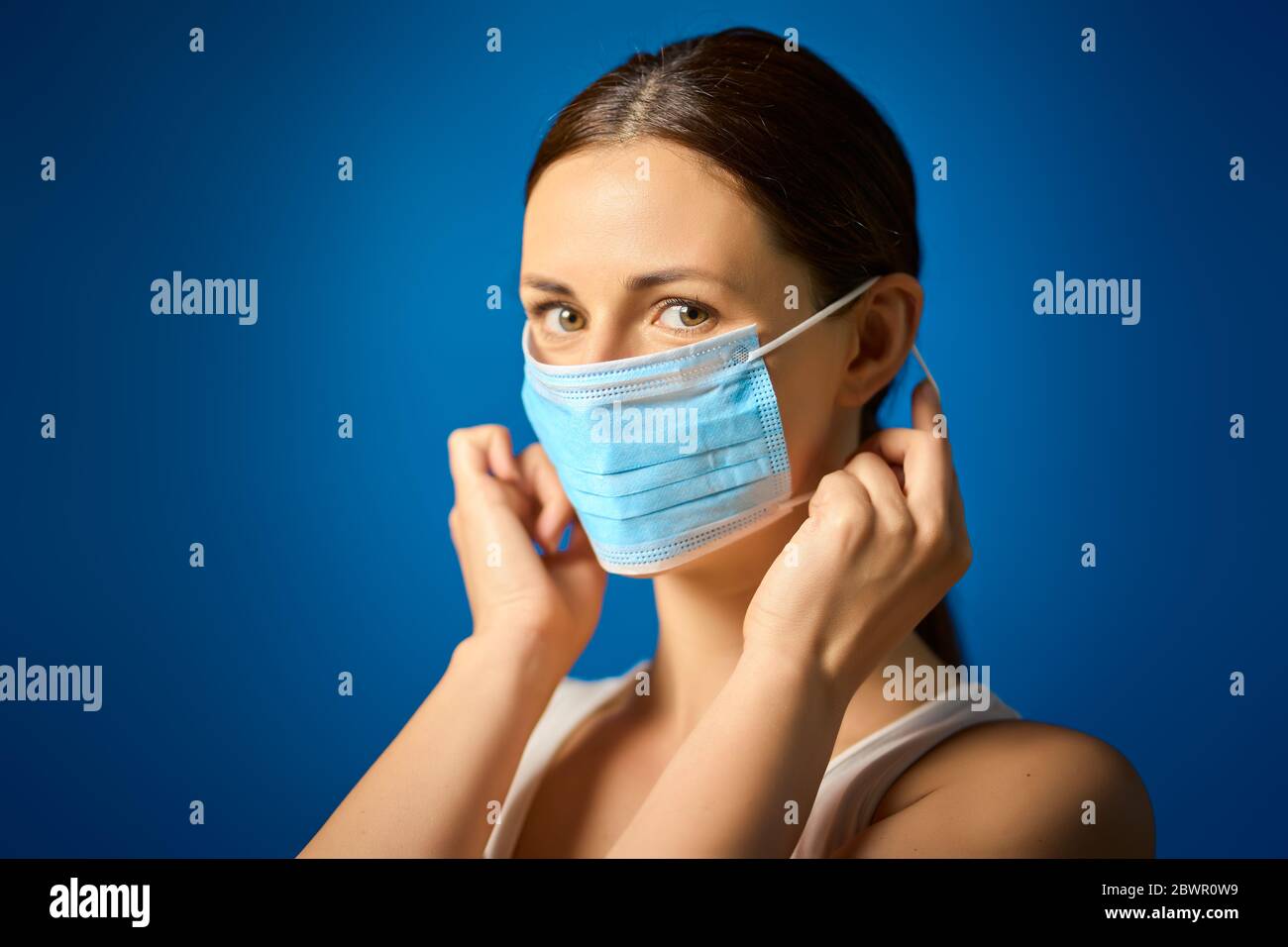 woman in white shirt shows how to wear a mask during a pandemic Stock Photo