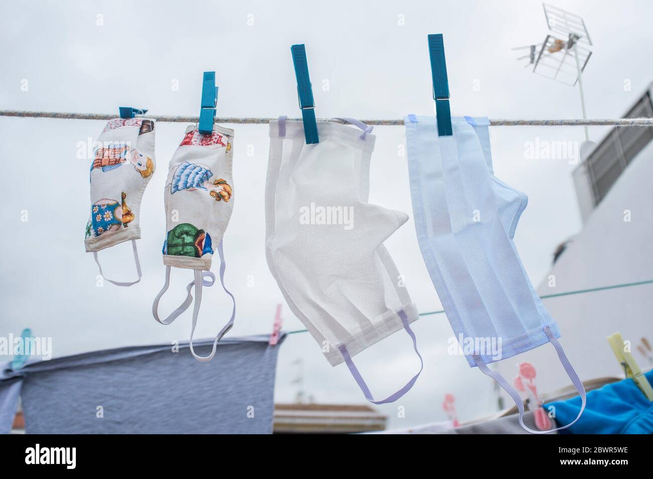 Set of washable face masks hanging on a clothesline. The set depicts the family together against covid-19. Stock Photo