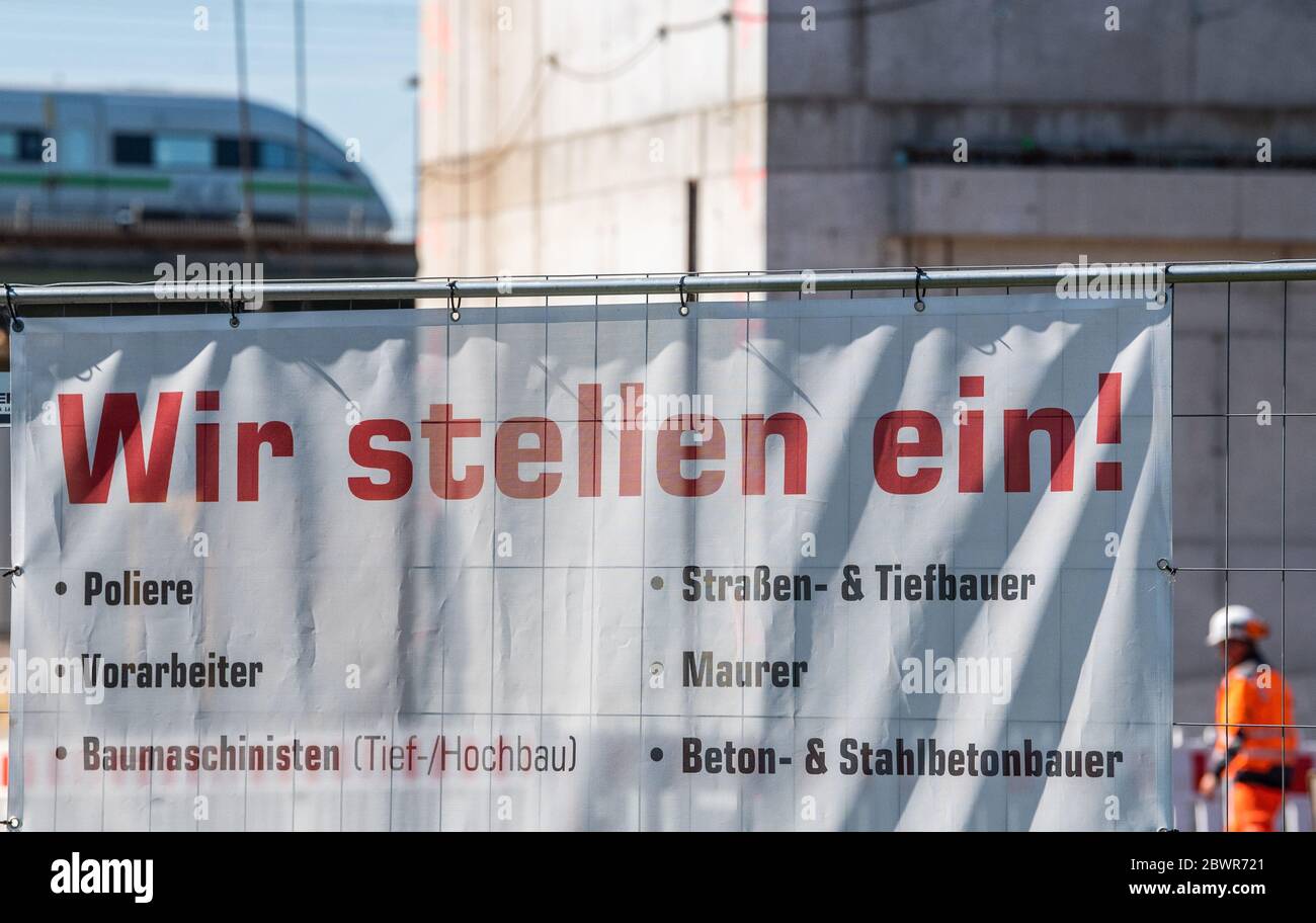 Dresden, Germany. 03rd June, 2020. A banner with the inscription 'Wir einstellen!' hangs on a construction fence of a building site, in the background an ICE train is crossing the Marienbrücke. On 03.06.2020 the employment agency announces the labour market figures for May 2020. Credit: Robert Michael/dpa-Zentralbild/dpa/Alamy Live News Stock Photo