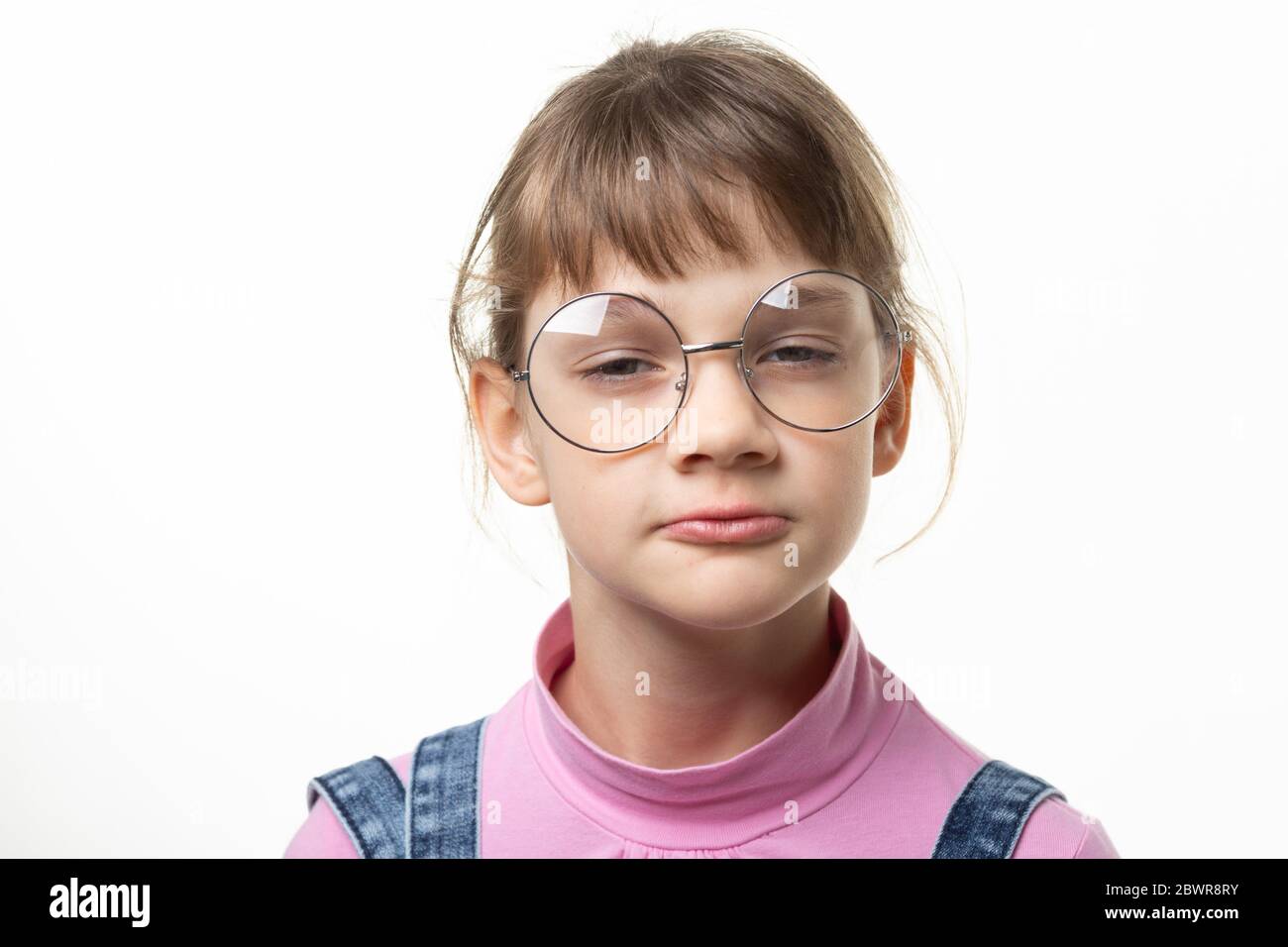 Portrait of a funny girl in glasses squinting eyes on a white
