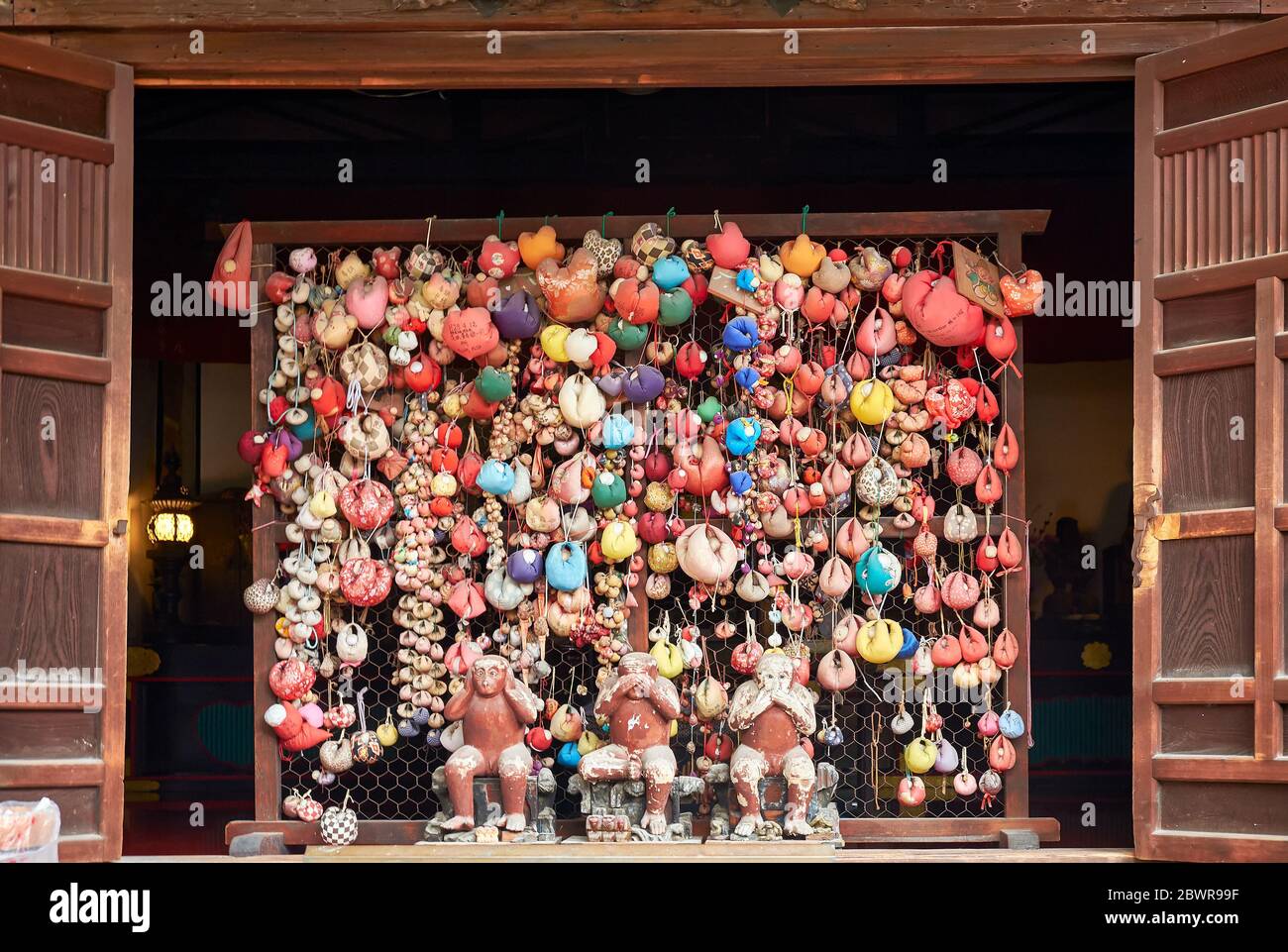 KYOTO, JAPAN - OCTOBER 18, 2019:  The three hear no evil, see no evil, speak no evil monkeys surrounded by colorful balls (kukurizaru) with wishes at Stock Photo