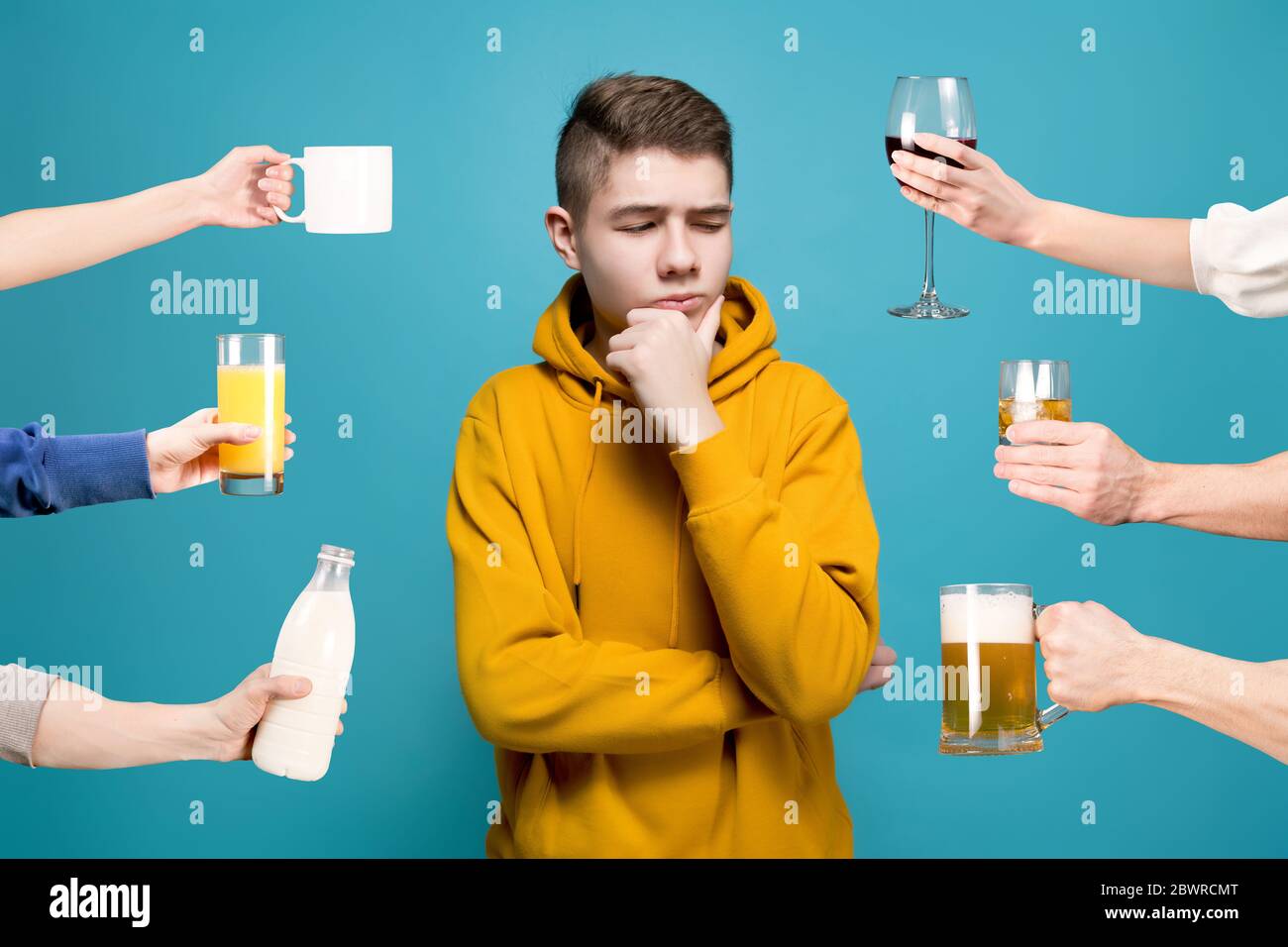 A young man in a sweatshirt looks doubtfully at an imaginary obj Stock Photo
