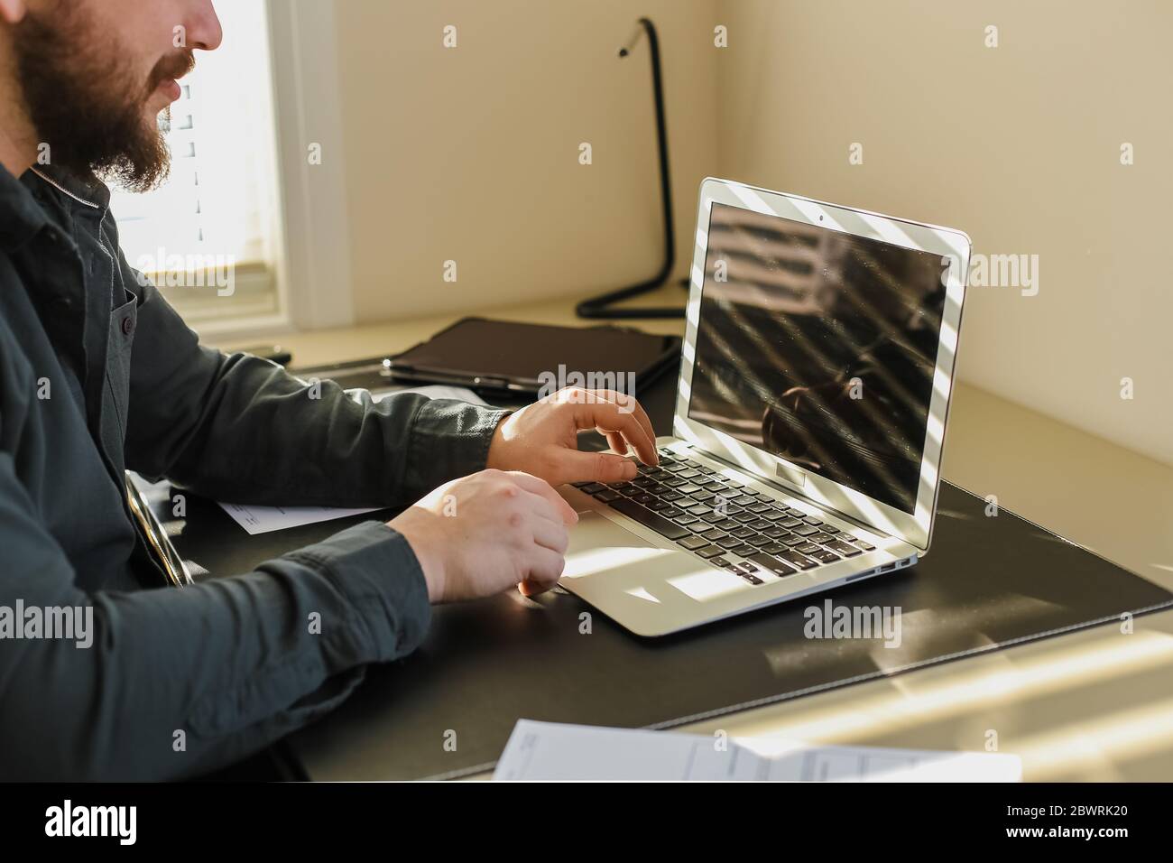 Male programmer writing program at office on laptop, typing on keyboard. Stock Photo