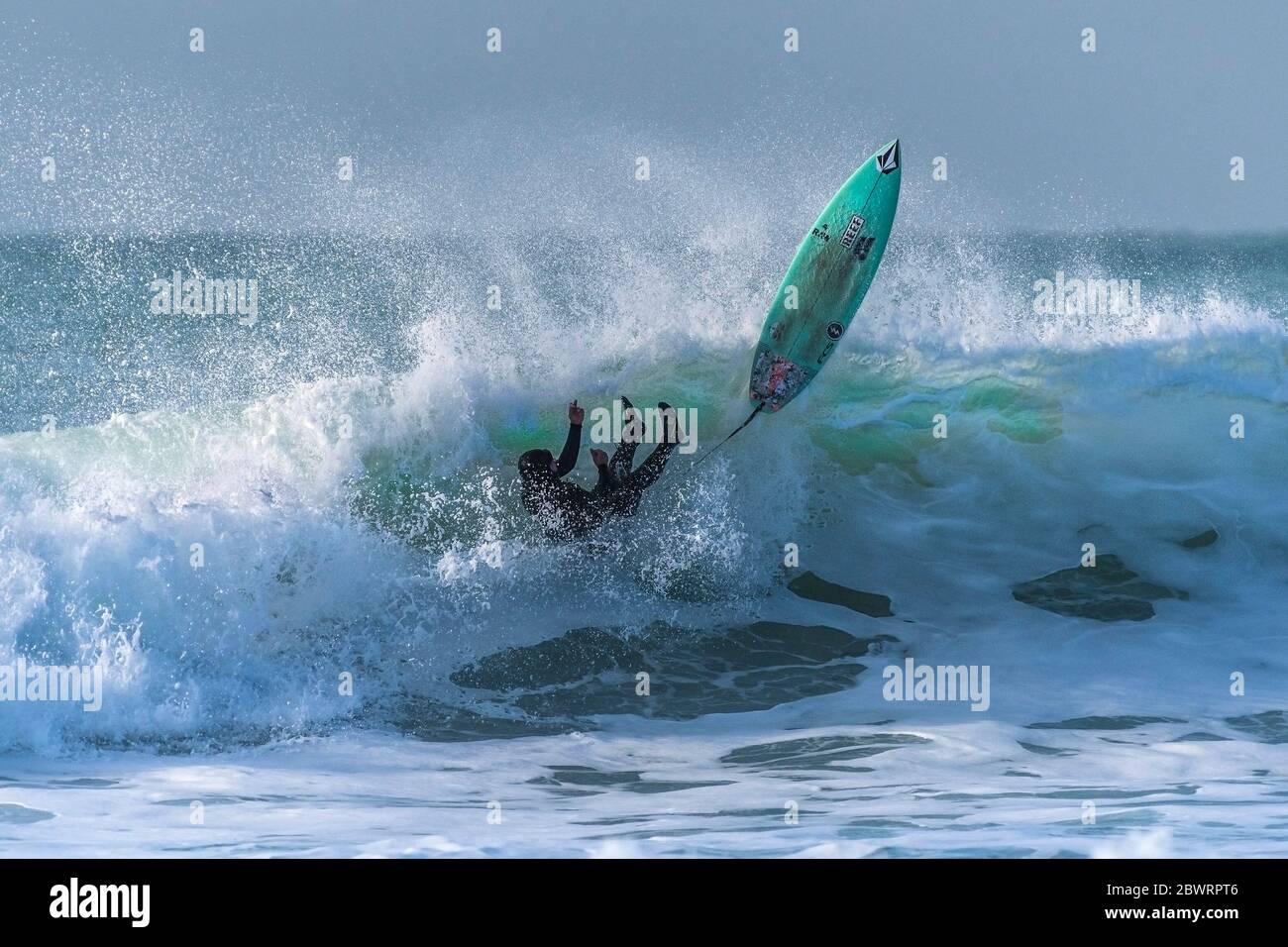 Spectacular surfing action as a surfer wipes out on a wild wave at Fistral in Newquay in Cornwall. Stock Photo
