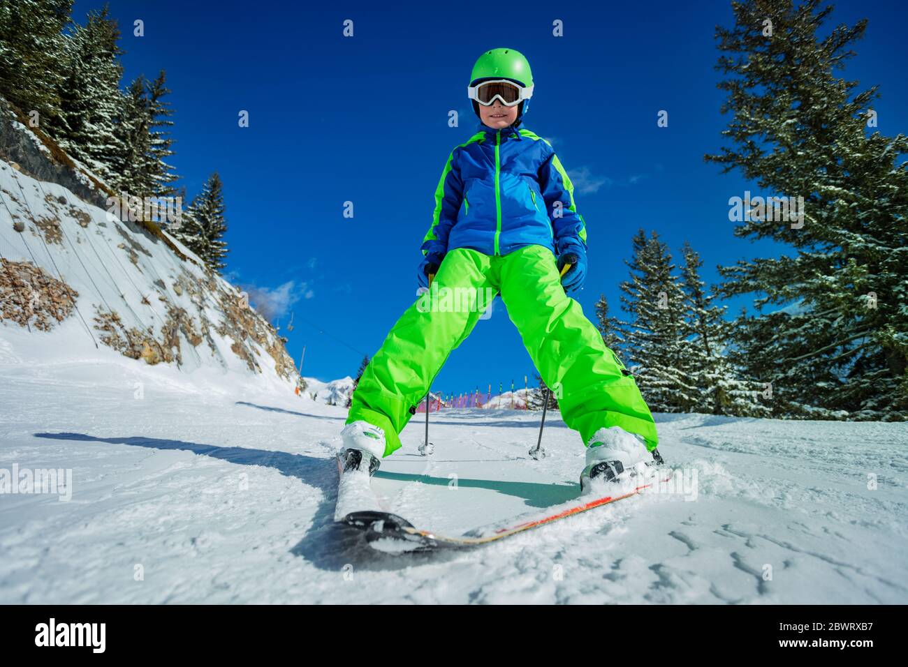Fun portrait of happy 10 years old boy skier learning to ski down the