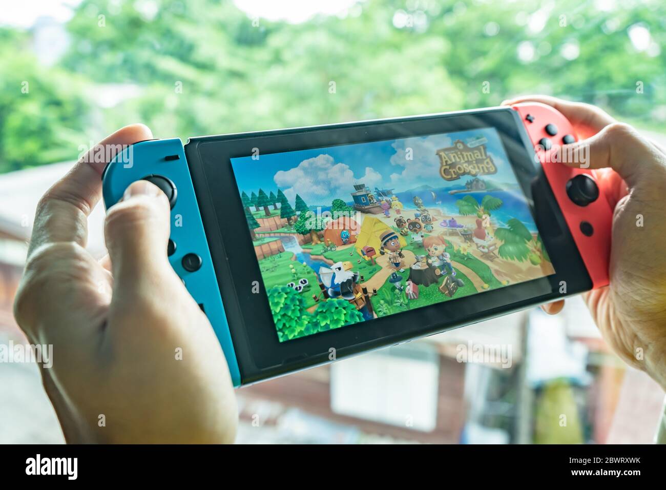 Bangkok, Thailand - May 26, 2020 : A man playing Animal Crossing on Nintendo Switch. Stock Photo