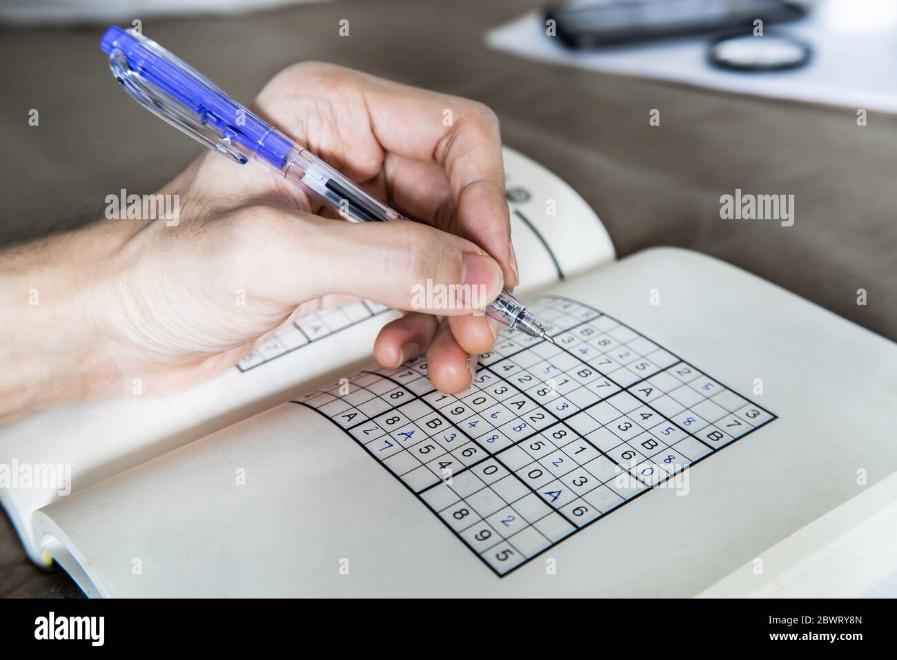 Writing on Sudoku puzzle with ballpoint pen Stock Photo