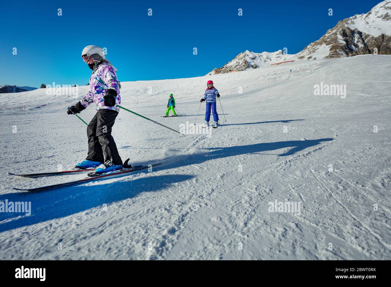 Group Of Kids In Ski School Move Downhill One After Another On Wide Easy Slope Stock Photo Alamy