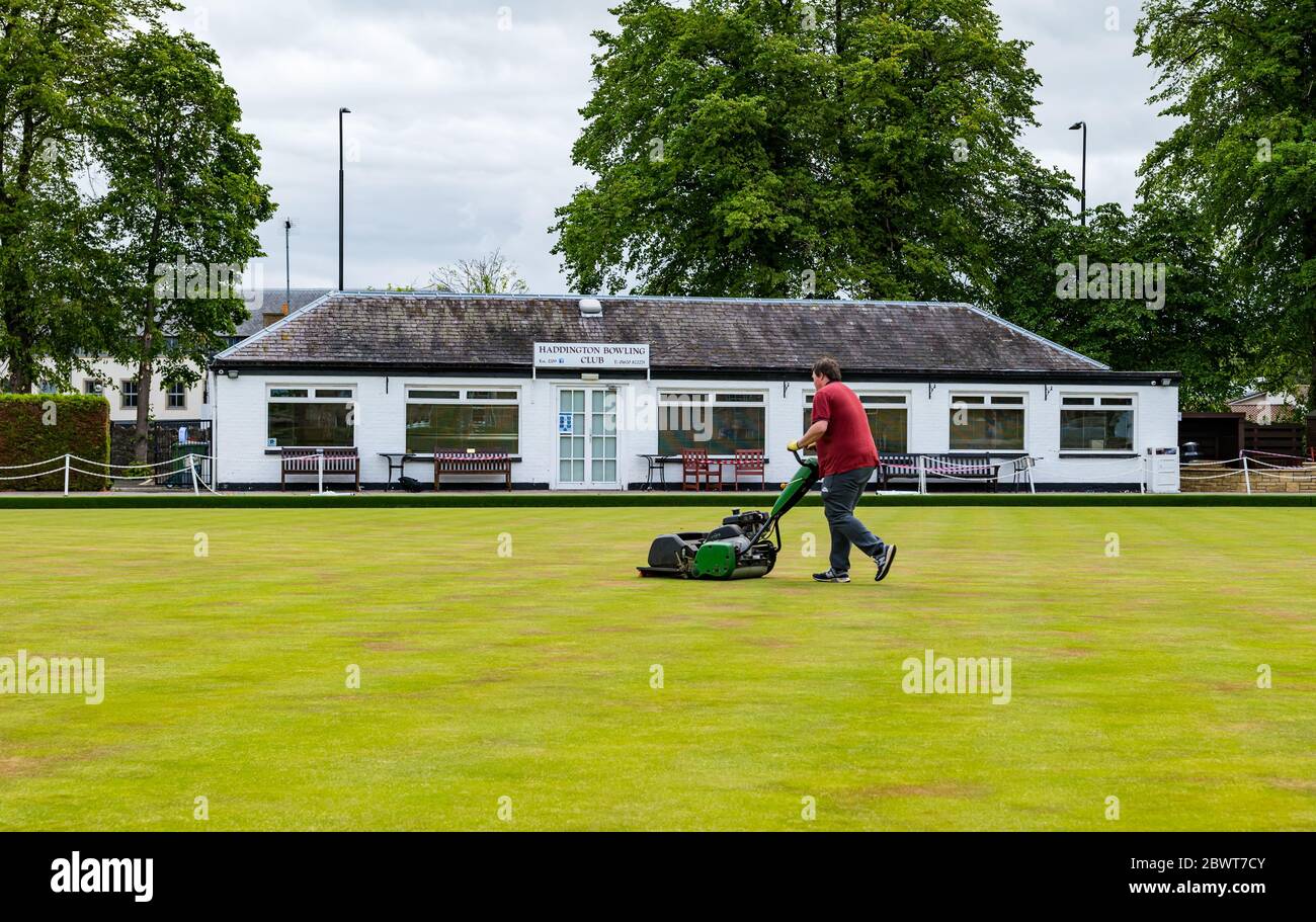 Haddington, East Lothian, Scotland, UK, 03 June 2020. Scotland's oldest bowling club reopens after lockdown restrictions are eased. The club celebrated its 300th anniversary in 2009, and has about 75 full members. Pictured: Mark McWilliams, one of the club’s committee members who is currently furloughed, cuts the grass in preparation for the first players today Stock Photo