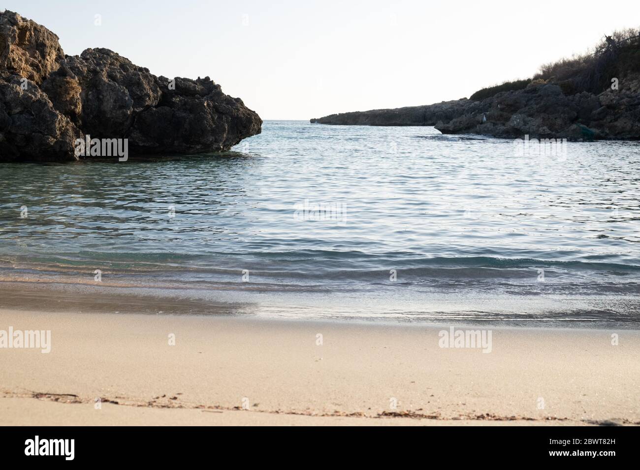 We are on a beach in southern Italy in Taranto, the water of the jonio-colored torche sea bathes the fine sand of the coast in the sunset hours. Stock Photo