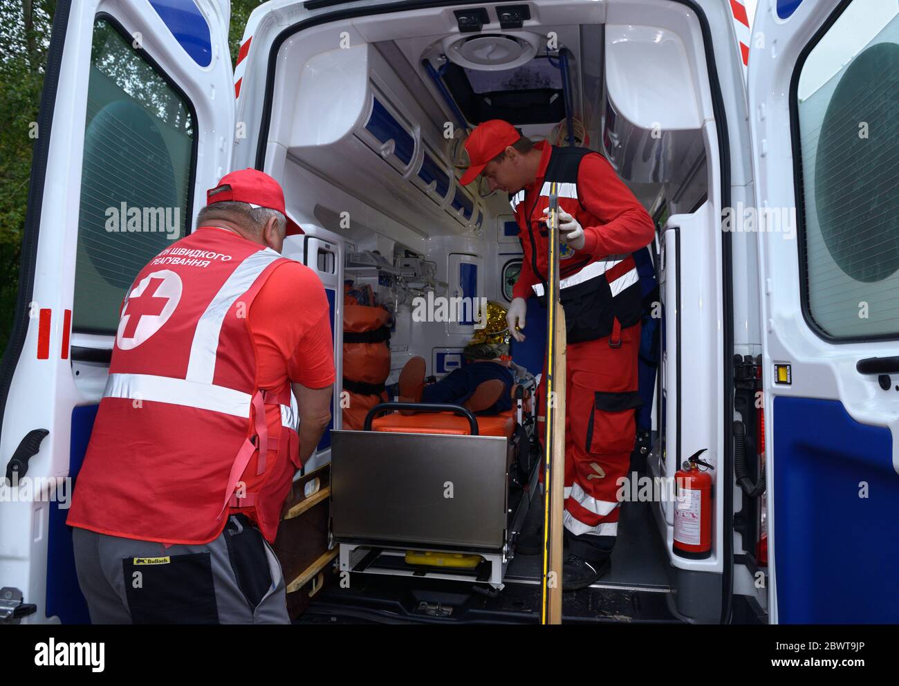 Paramedics putting the sufferer on the stretcher in the emergency car