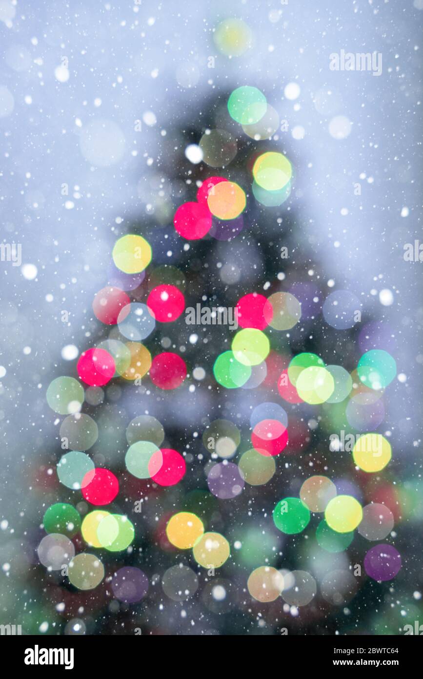 Blur Christmas tree lights decoration on purple background and snowflakes Stock Photo