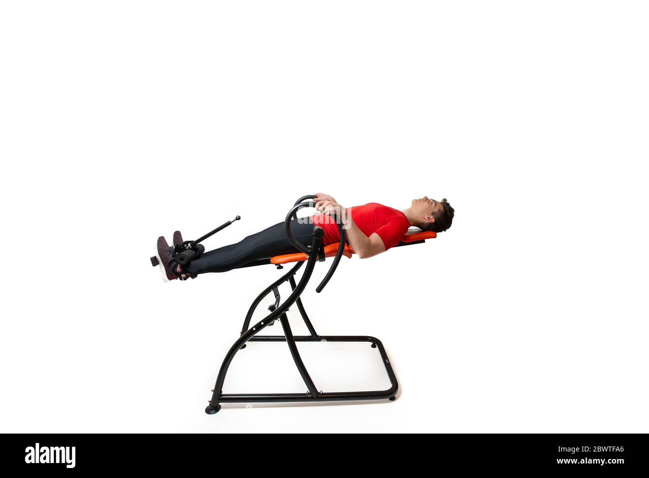 Man doing exercise on inversion table for his back pain, isolated on