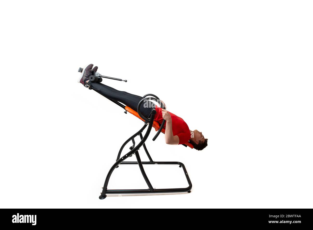 Man doing exercise on inversion table for his back pain, isolated on