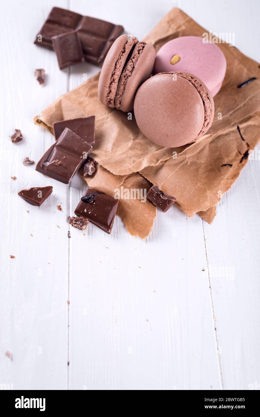 Chocolate french macaroons with chocolate pieces on white background with space under the text Stock Photo