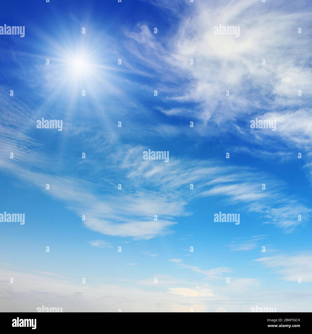 Bright sun on blue sky with beautiful white clouds Stock Photo
