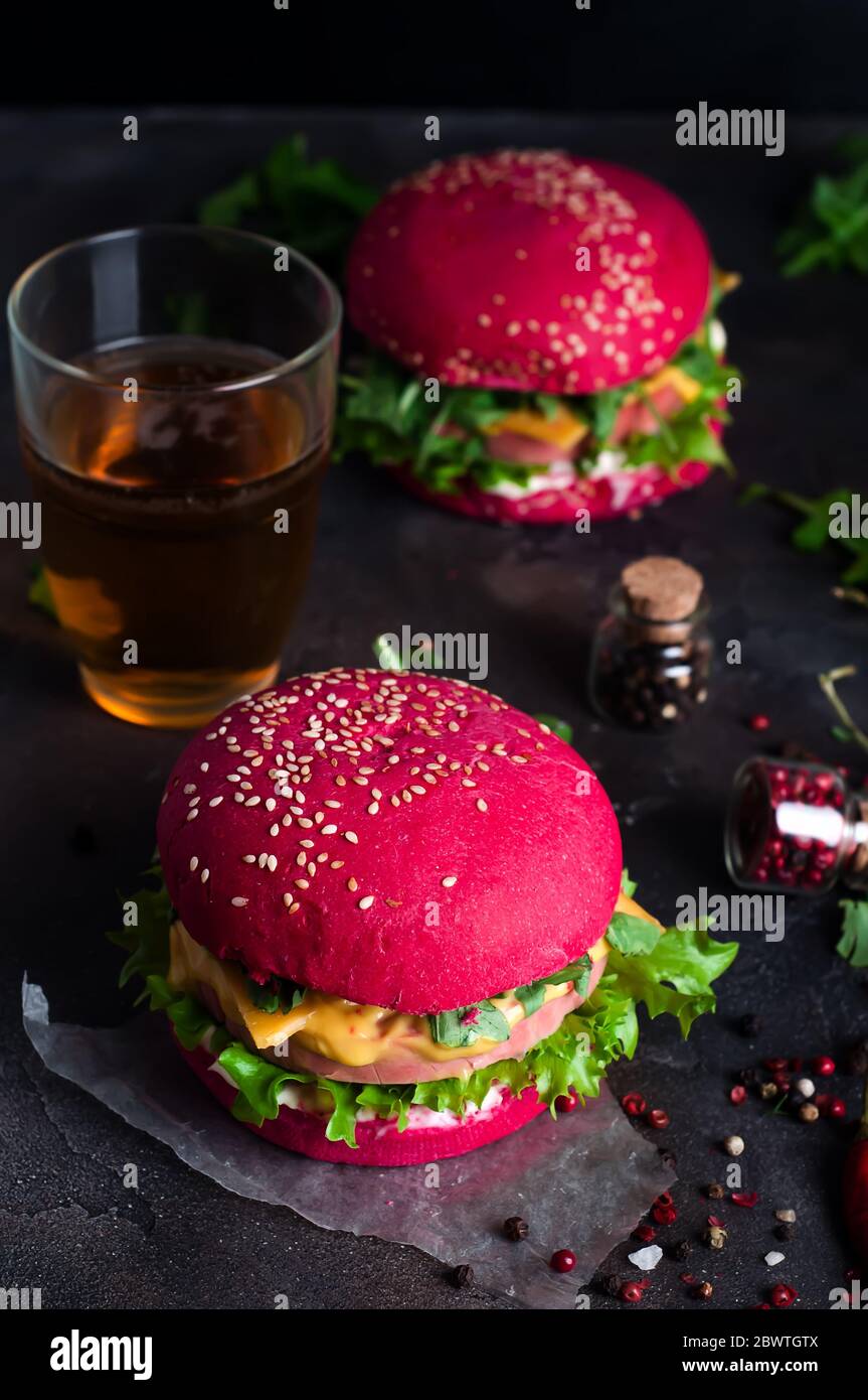 Burgers with red bun and greens on a black background Stock Photo