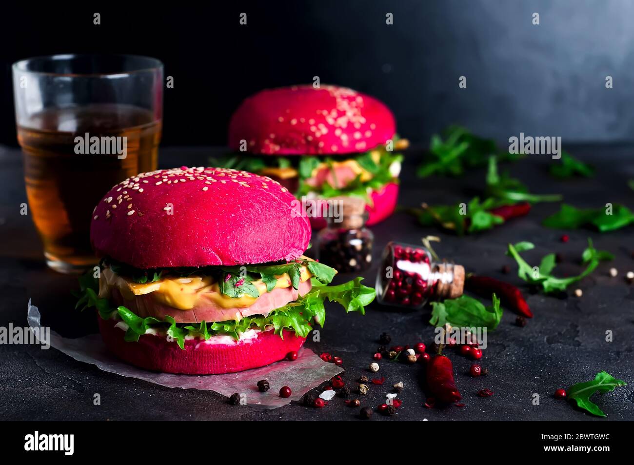 Burgers with red bun and greens on a black background Stock Photo