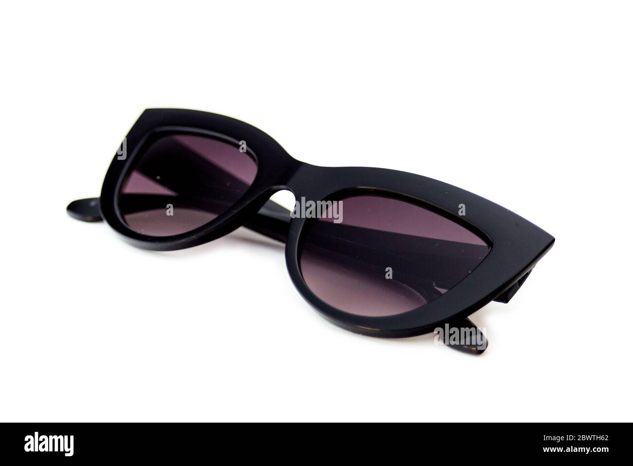 Black colored thick frame cat eye sunglasses isolated on white background. Earpiece parts are