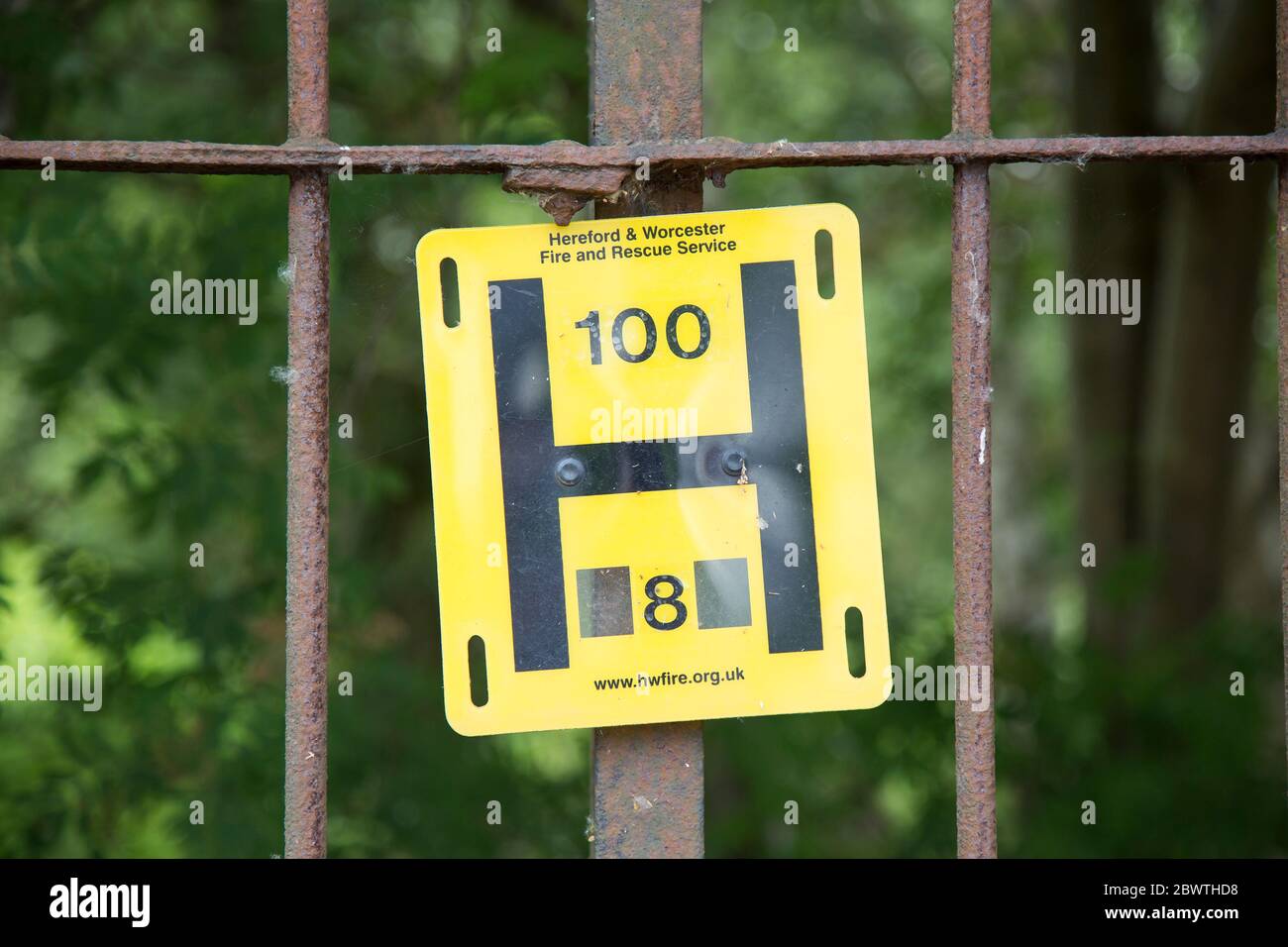 Close up yellow UK fire hydrant sign isolated outdoors on railings, indicator to Fire & Rescue Service location of nearest water supply. Water hydrant. Stock Photo