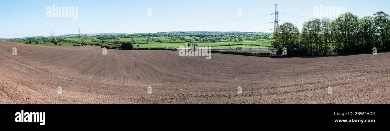 Around the UK - A sweeping view from the edge of the village of Brindle towards Darwen Moors, across a freshly planted field. Stock Photo