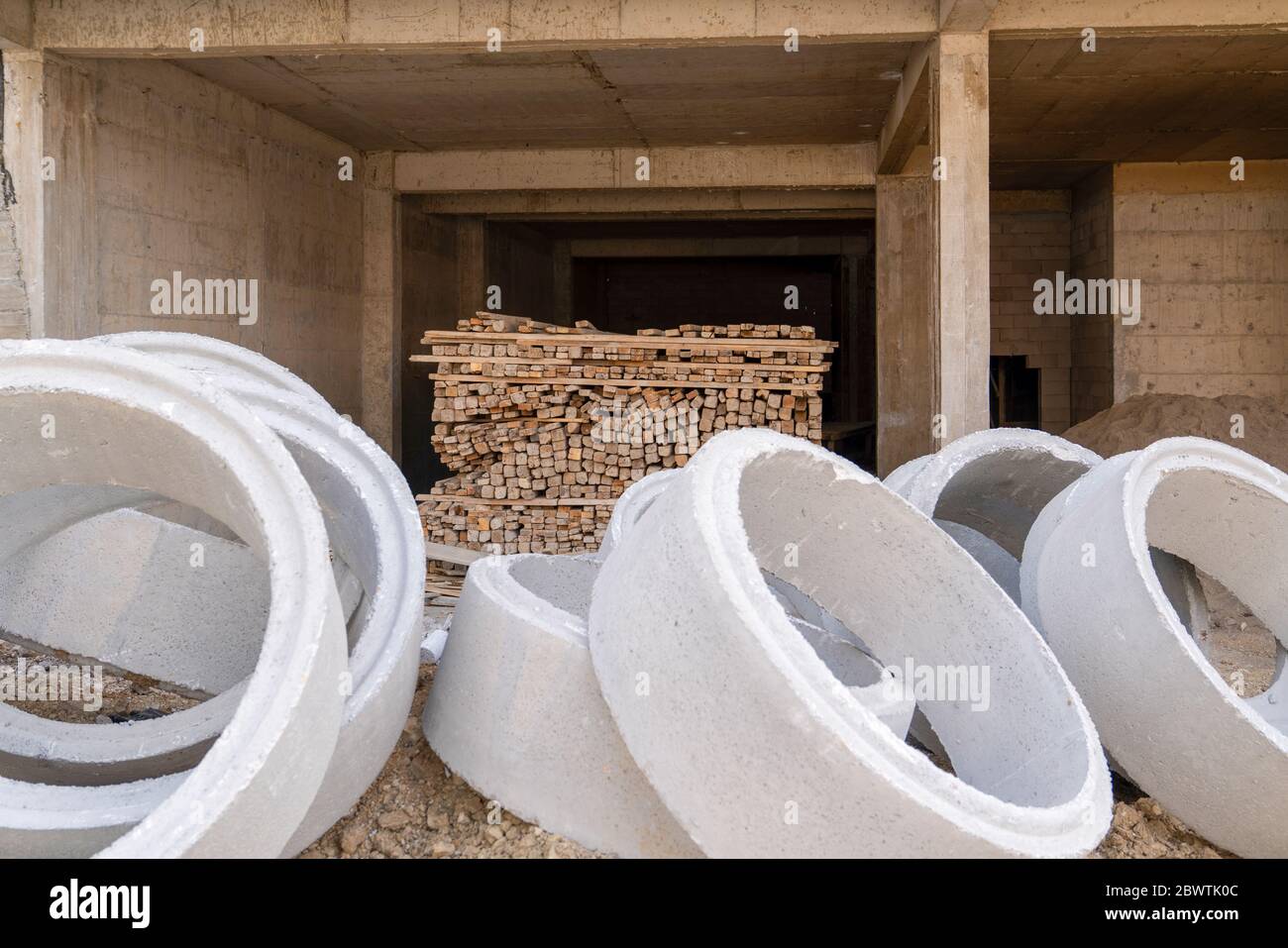 House under construction with timber and concrete pipes. Stock Photo