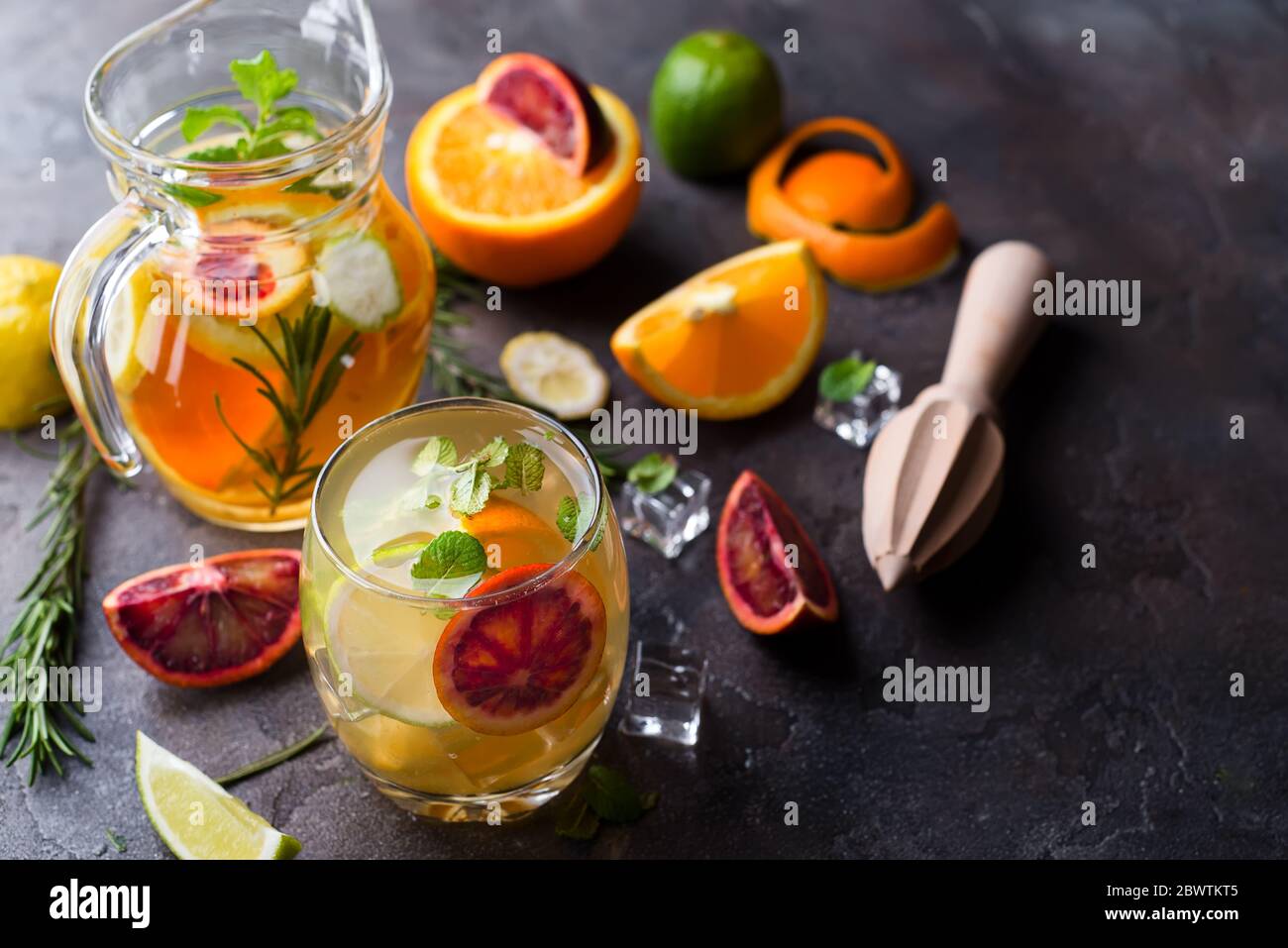 refreshing cocktail with red blood orange, ice and mint on a dark stone ...