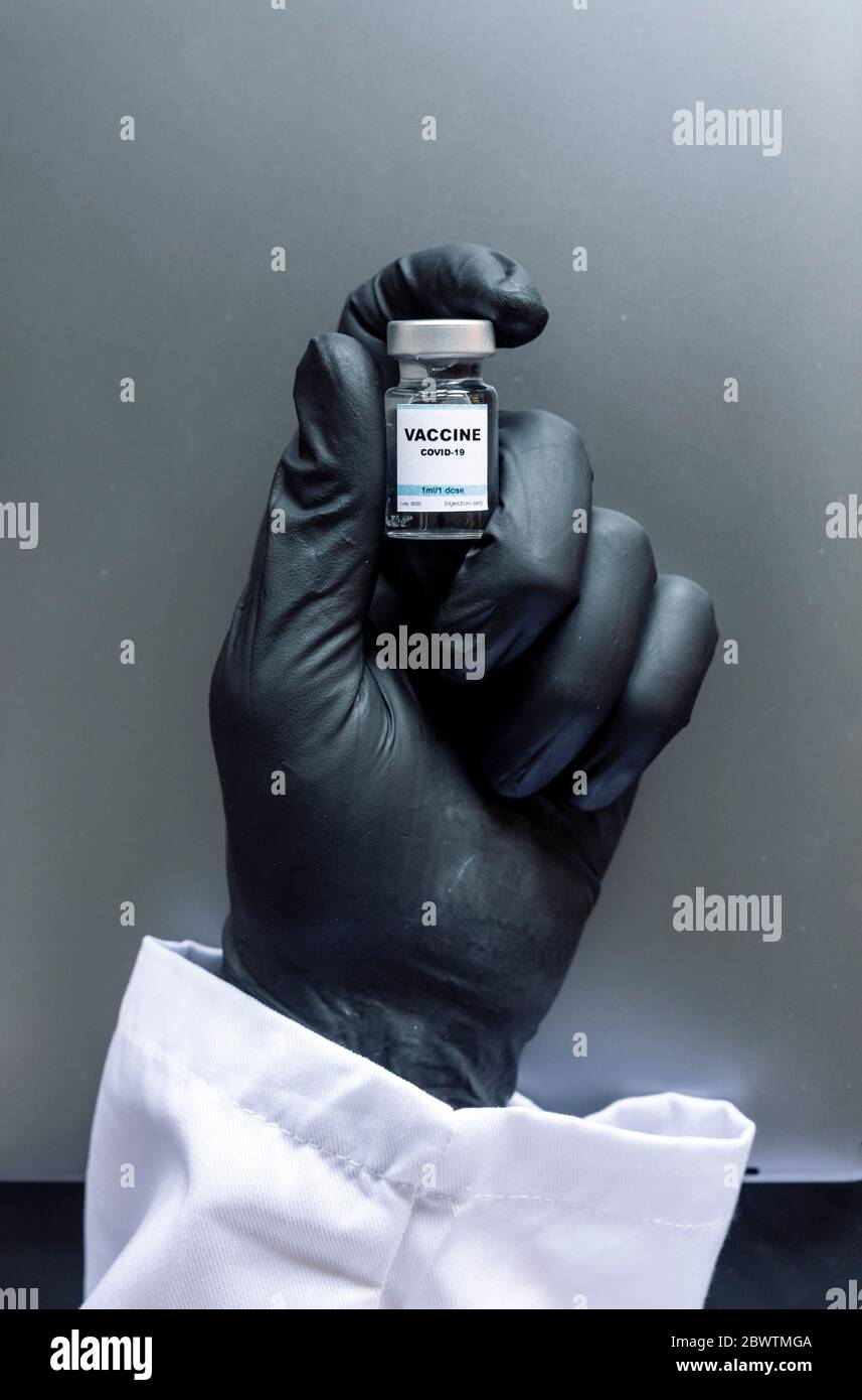 Cropped image of scientist's hand holding COVID-19 vaccine sample at laboratory Stock Photo