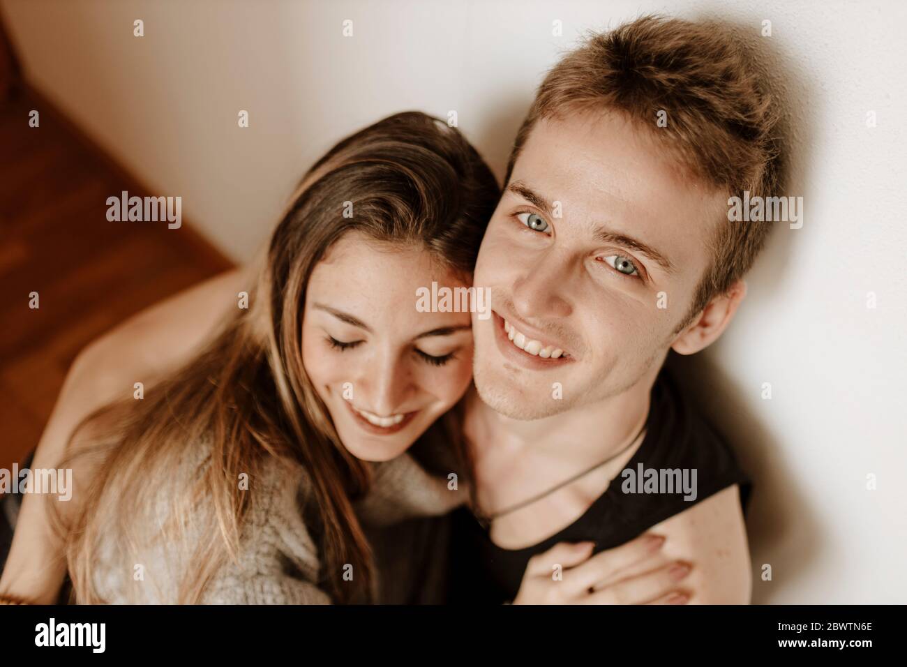 Happy young couple sitting on the floor at home Stock Photo