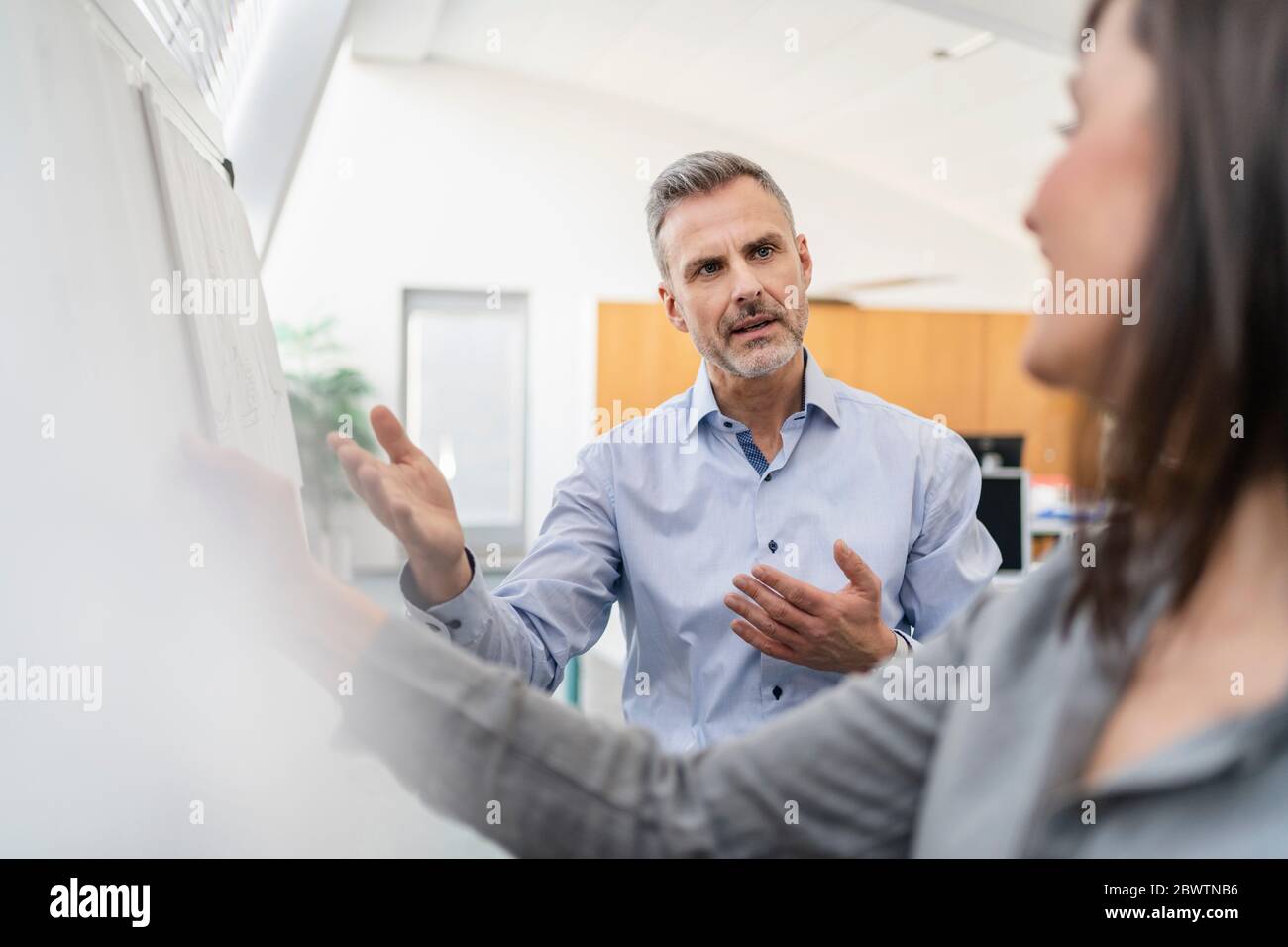 Businessman and businesswoman having a meeting in office Stock Photo ...