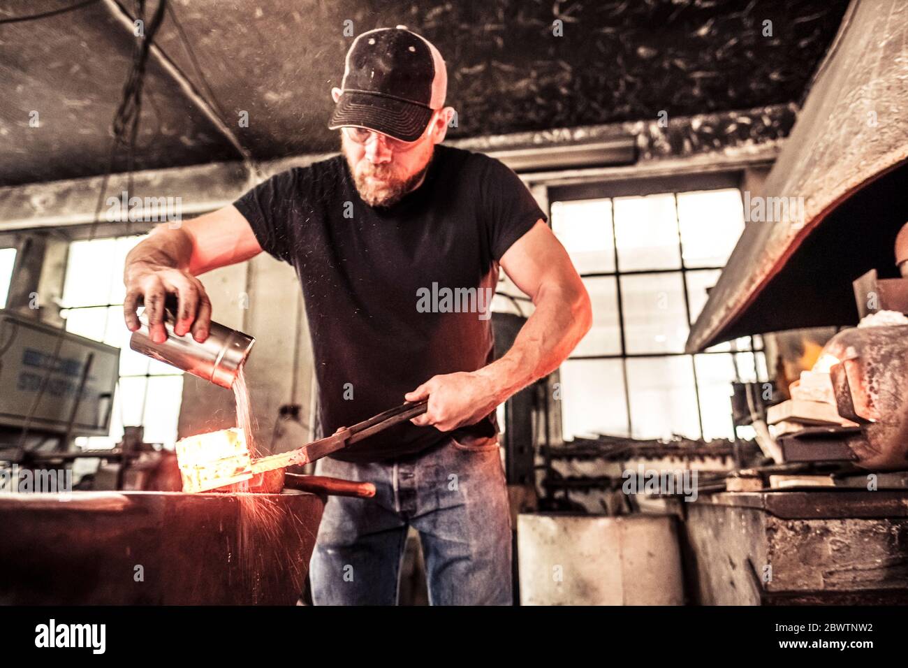 Knife maker working scattering borax over hot damask steel Stock Photo