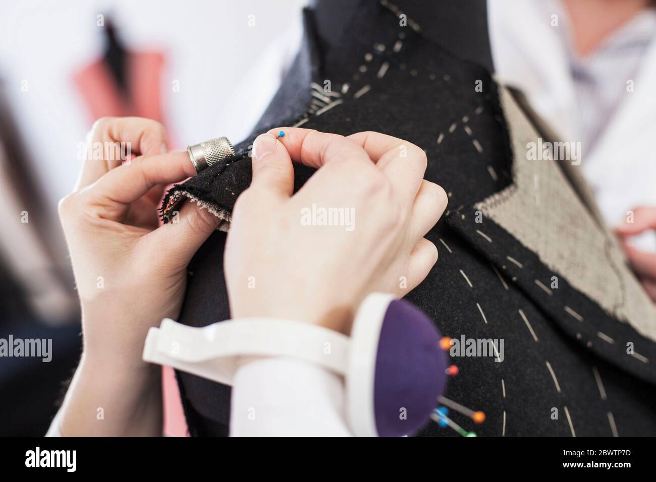 Close-up of seamstress pinning suit jacket Stock Photo