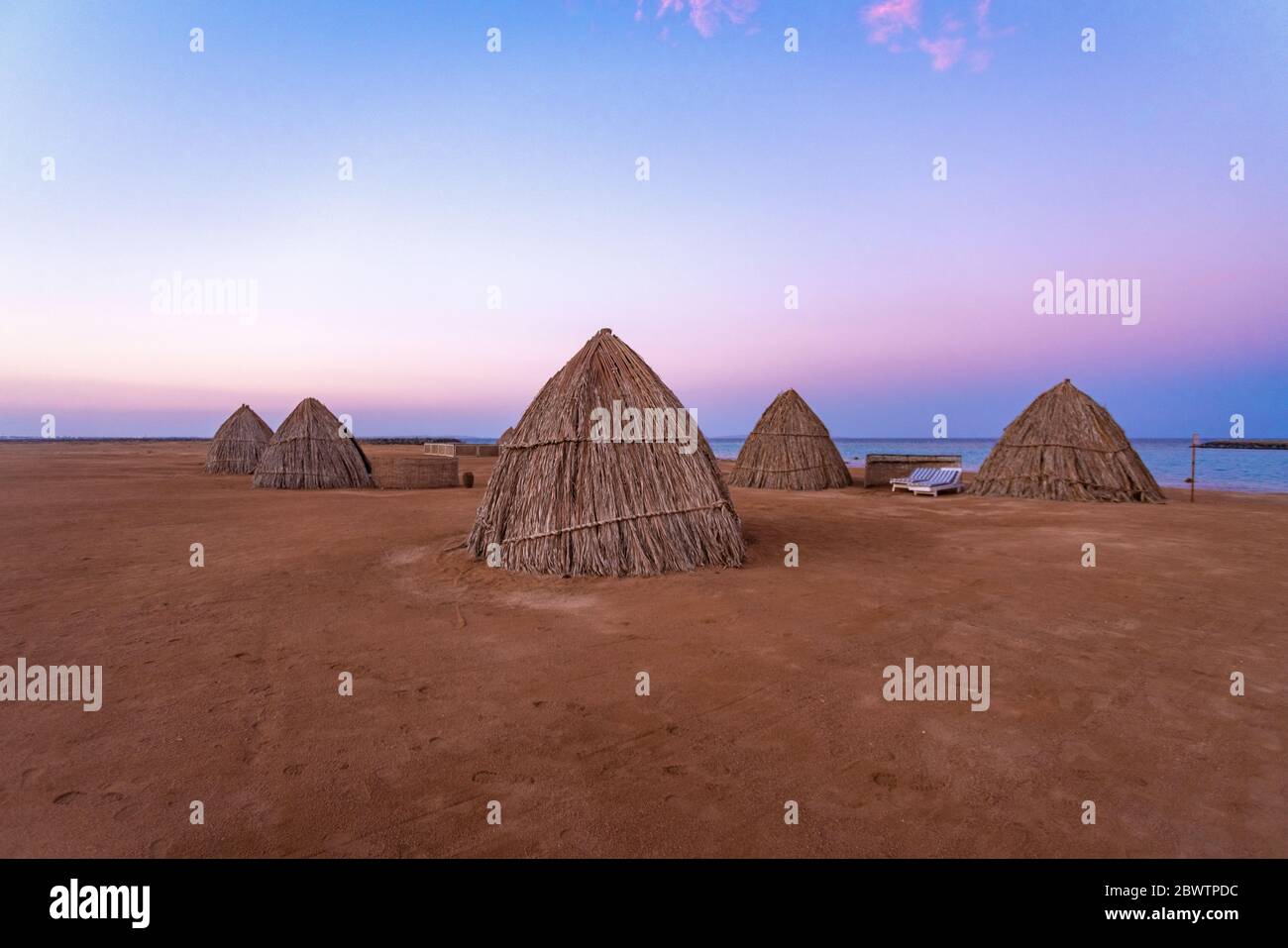 Egypt, Hurghada, Straw huts on sandy beach of Sahl Hasheesh bay at dawn Stock Photo