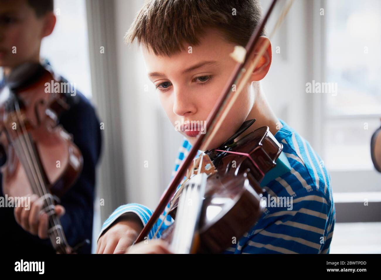 Boy playing violin during a lesson Stock Photo