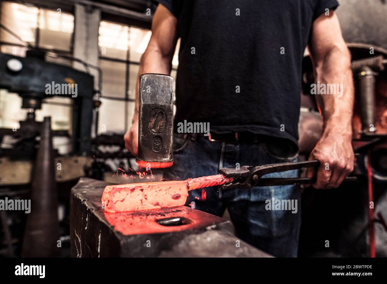 Knife maker working scattering borax over hot damask steel Stock Photo