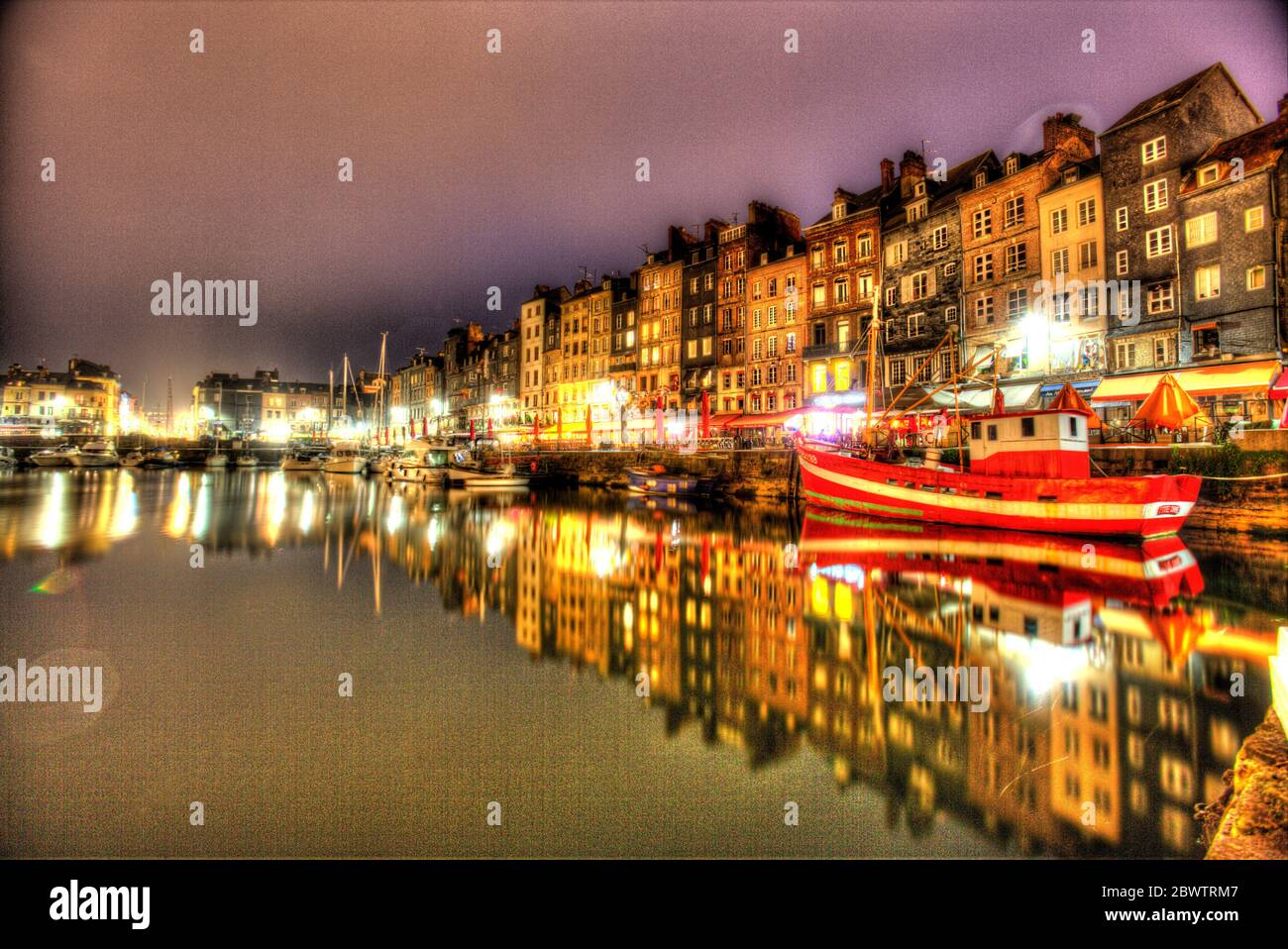 Town of Honfleur, France. Artistic night view of Honfleur’s Vieux Basin with the Quai Sainte