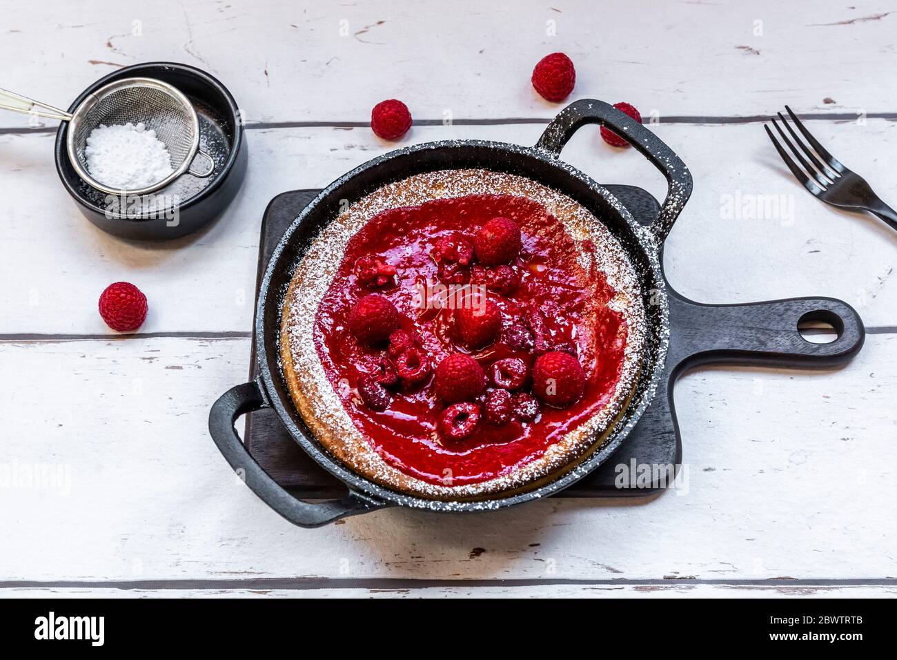 Dutch baby pancake with raspberries, raspberry coulis and powdered