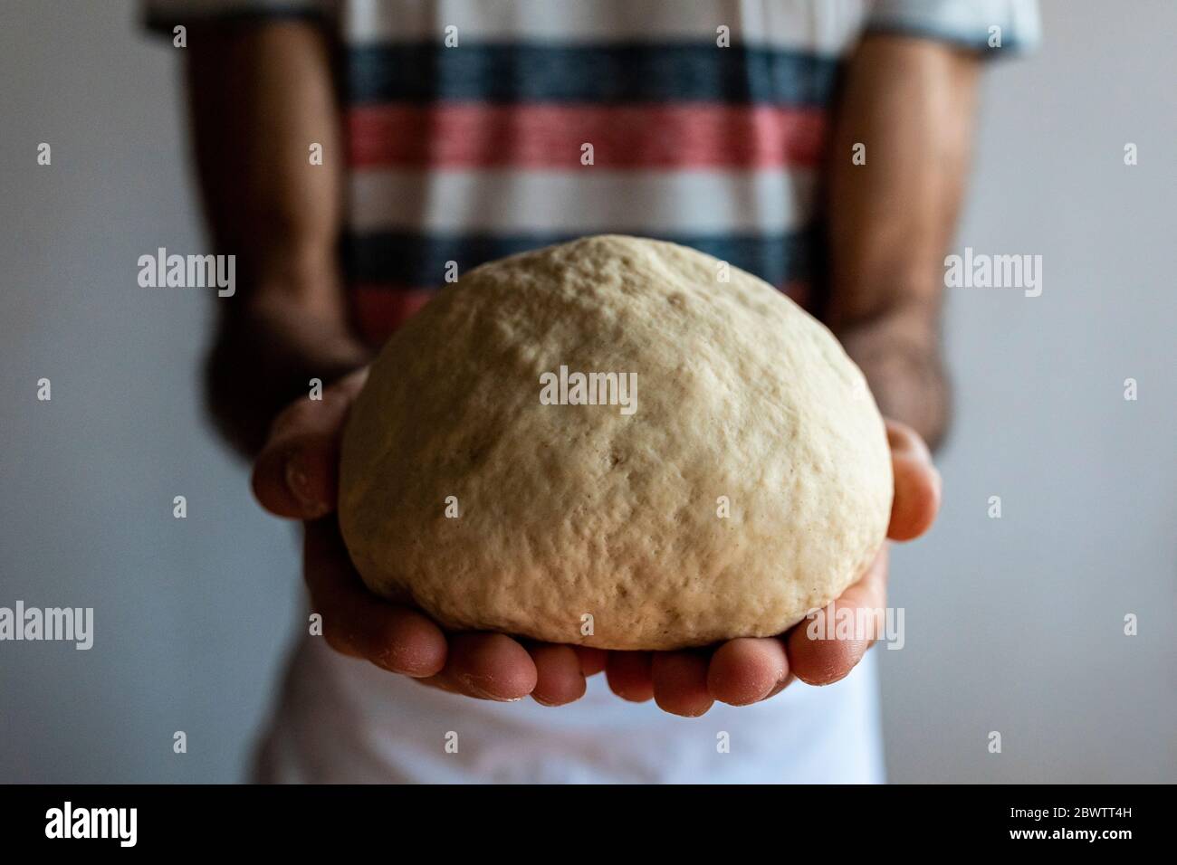 Man's hands holding dough ball, close-up Stock Photo