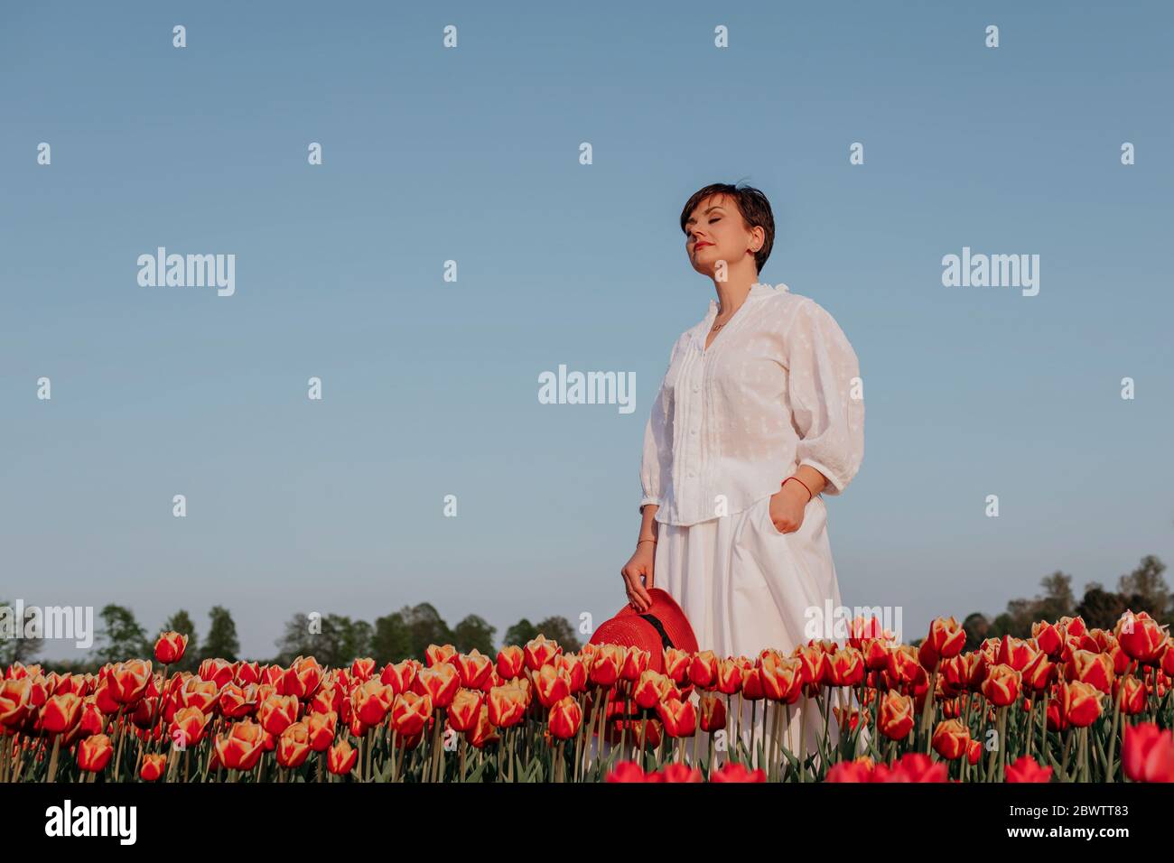 Portrait of woman with eyes closed  standing in tulip field Stock Photo