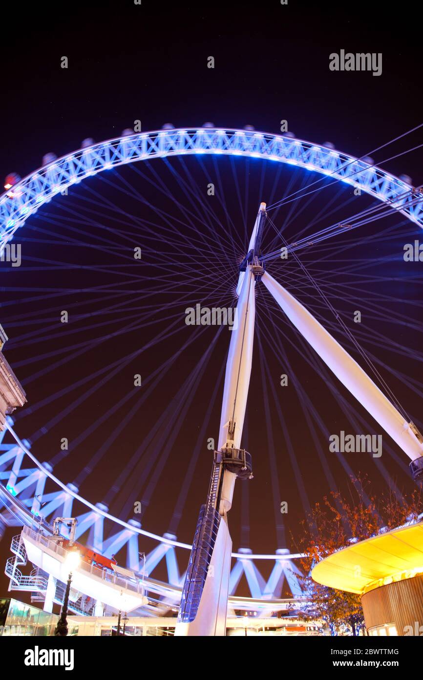 night time view of the London Eye observation wheel illuminated with purple blue lighting Stock Photo