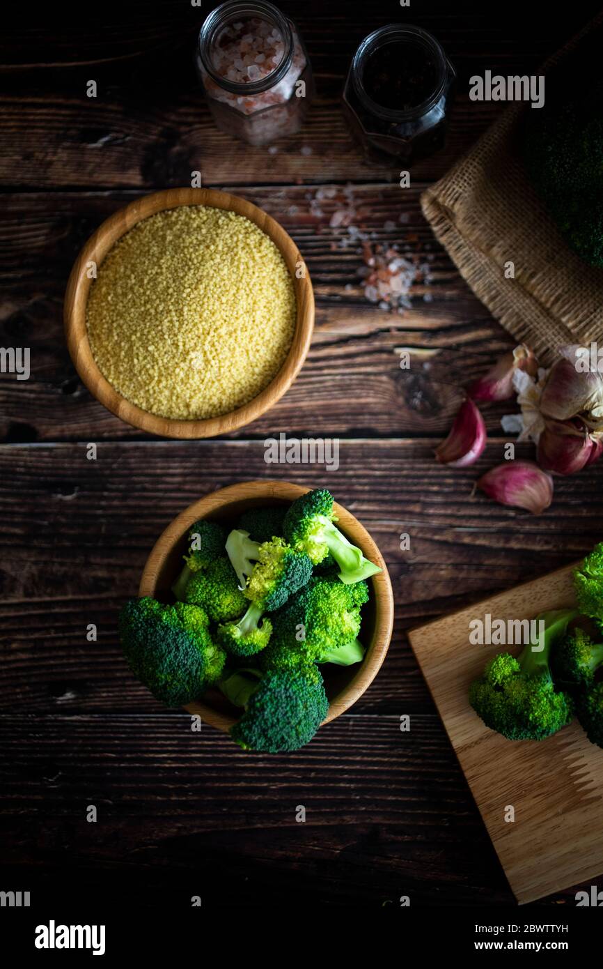 Salt and pepper, garlic, bowl of couscous and chopped broccoli Stock
