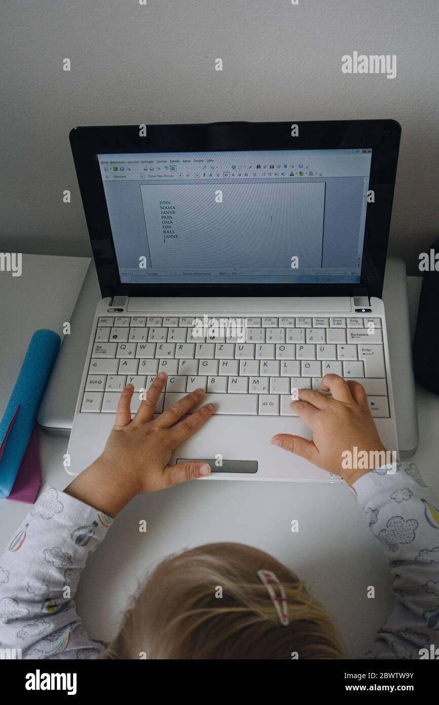 Crop view of little girl using laptop at home Stock Photo - Alamy
