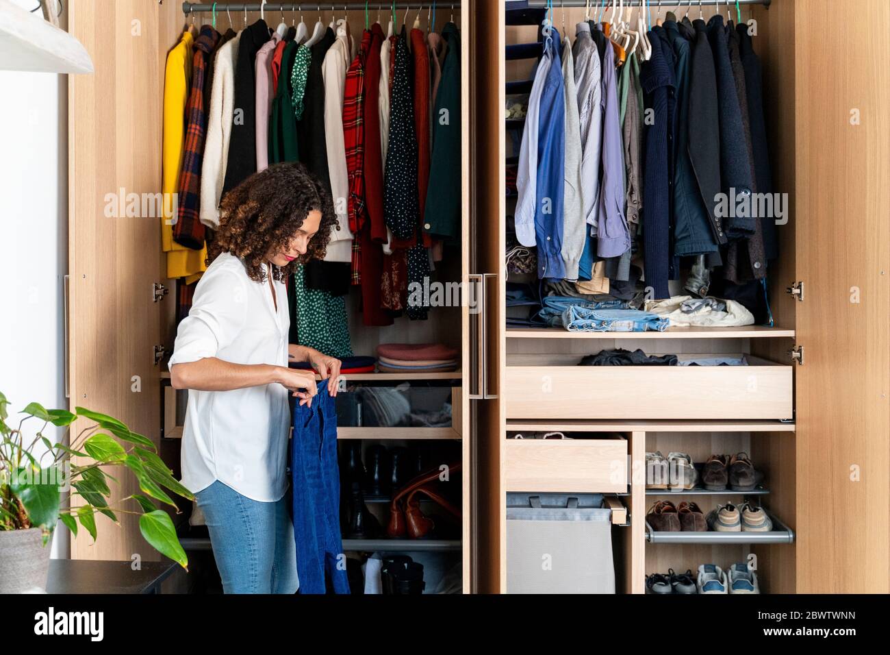 Woman clearing out her wardrobe Stock Photo