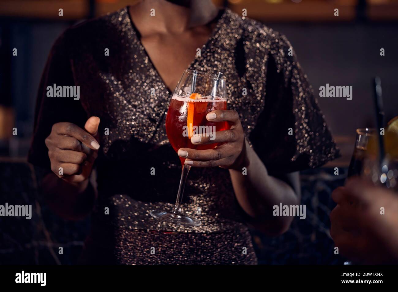Close-up of woman holding a cocktail glass in a bar Stock Photo