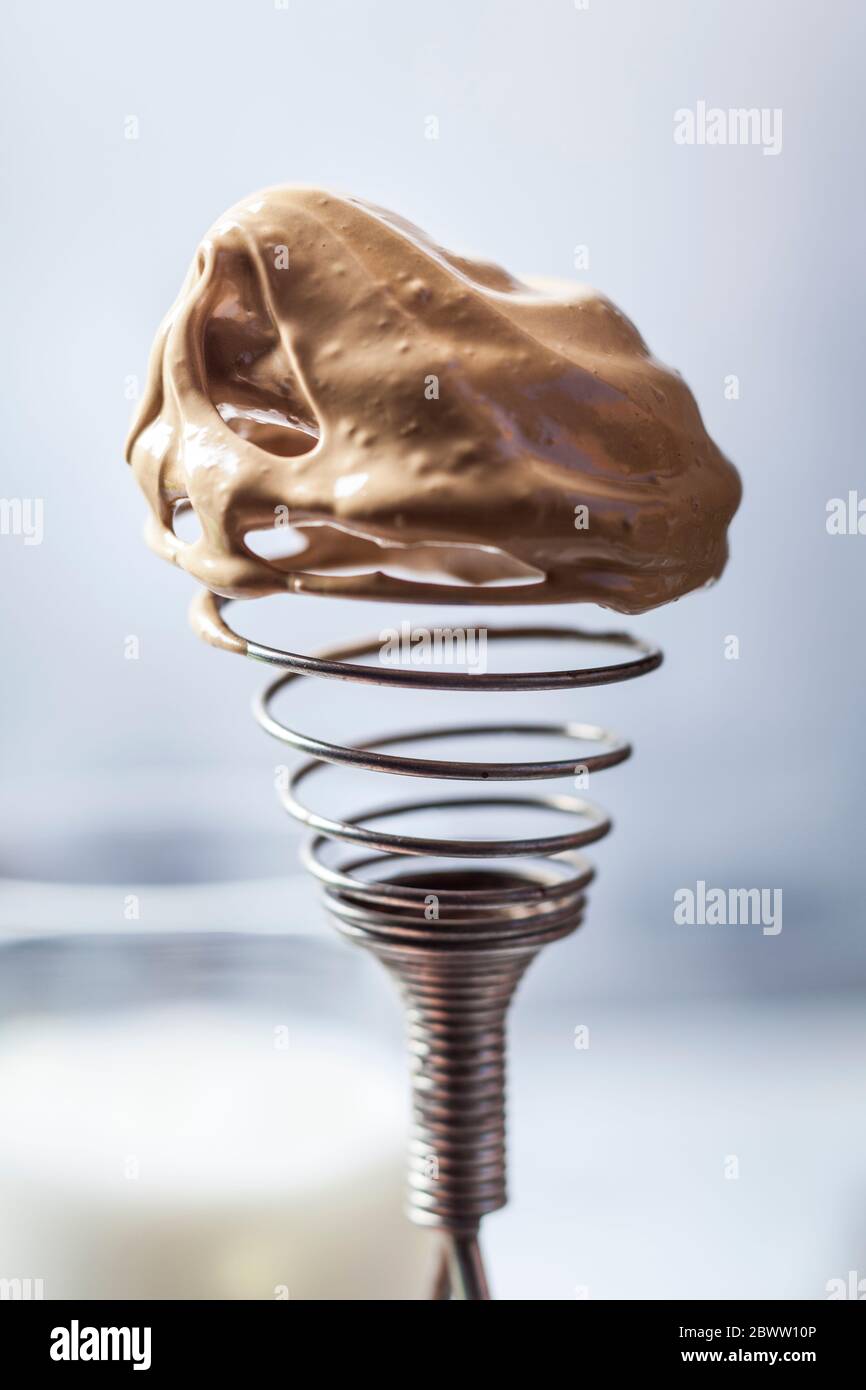 Close-up of wire whisk covered in dalgona coffee cream Stock Photo
