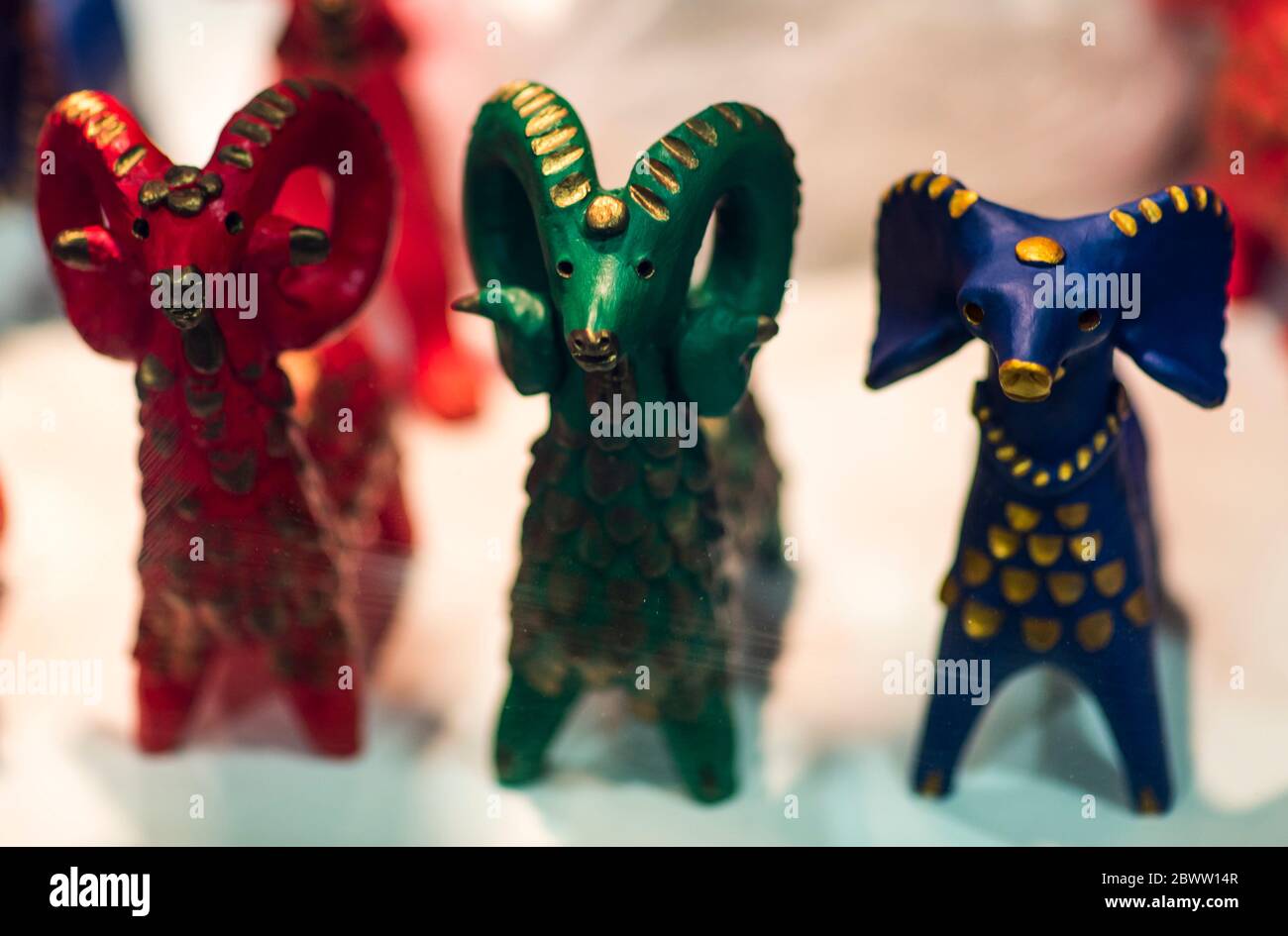 Beautiful vintage colourful wooden dymkovo dolls at market. Baphomet dolls is folks cultural symbol of Satanic cult. With selective focus on one doll Stock Photo