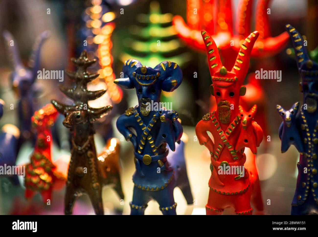 Beautiful vintage colourful wooden dymkovo dolls at market. Baphomet dolls is folks cultural symbol of Satanic cult. With selective focus on one doll Stock Photo