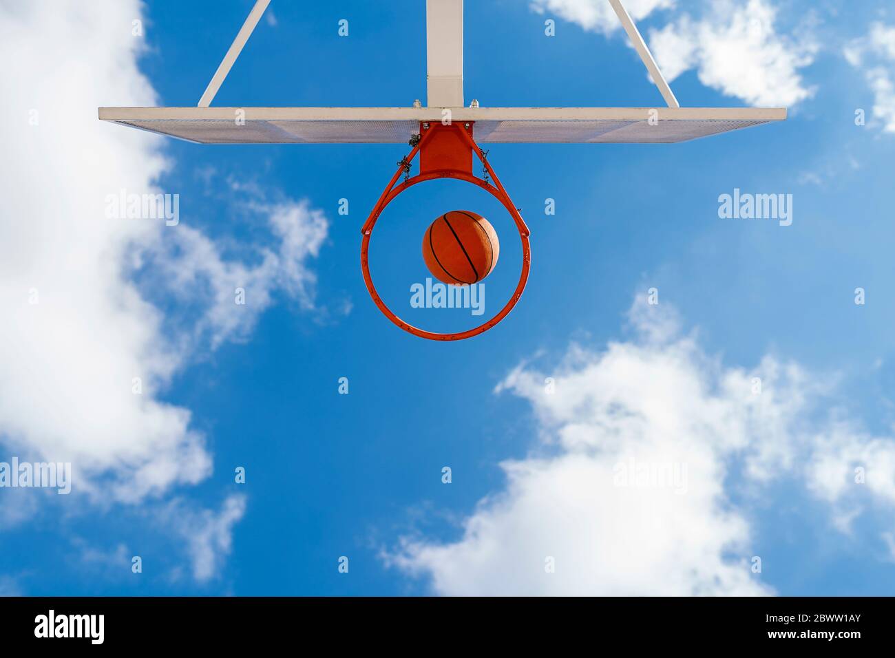 Basketball and hoop, blue sky, upward view Stock Photo Alamy