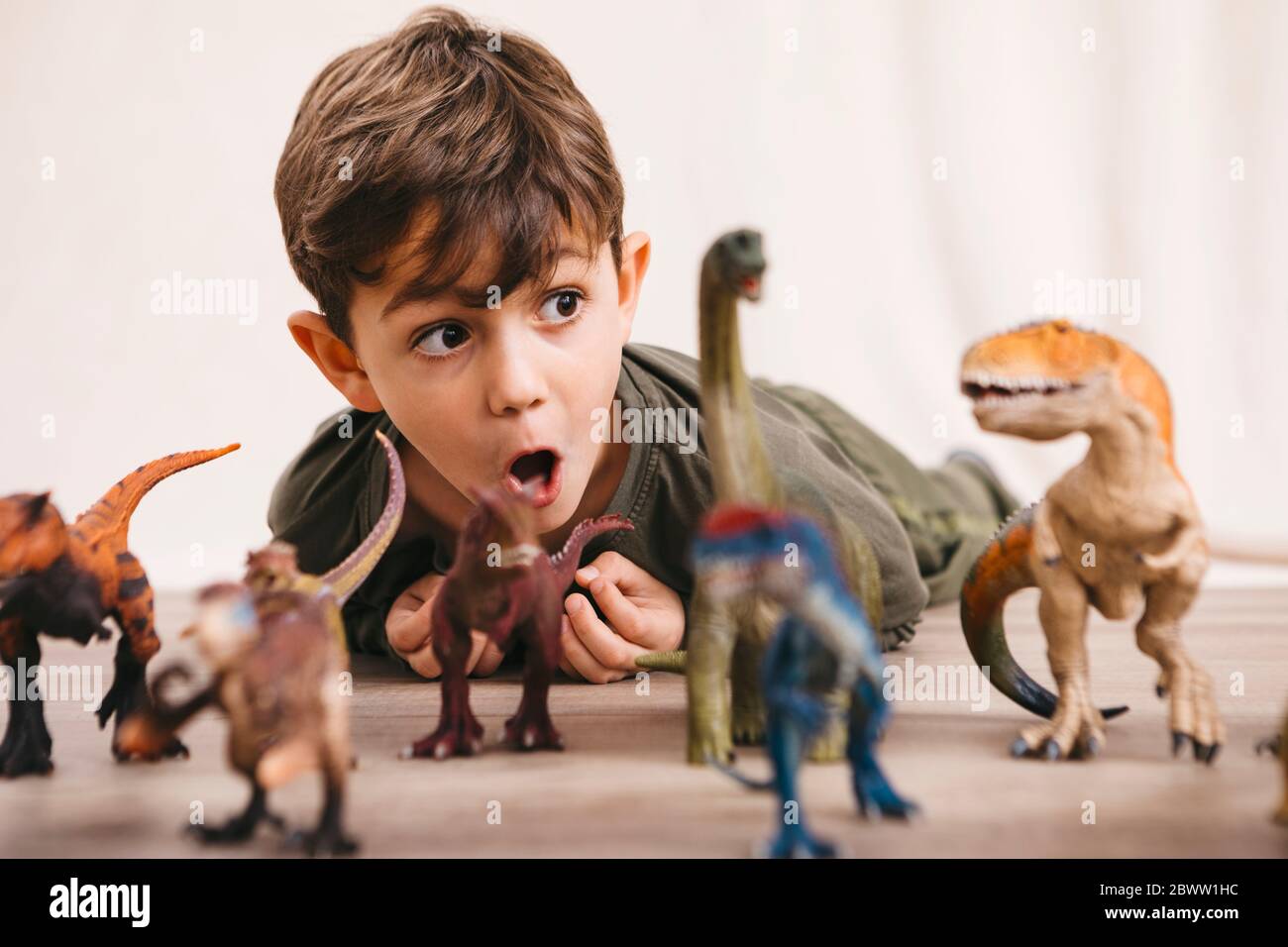 Portrait of little boy playing with toy dinosaurs Stock Photo