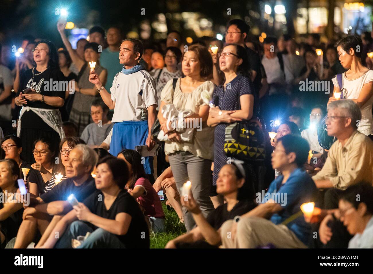 A crowd reflecting during a Candlelit Vigil for victims of the Tiananmen Square Massacre in Victoria Park, Hong Kong - 4th June 2019 Stock Photo